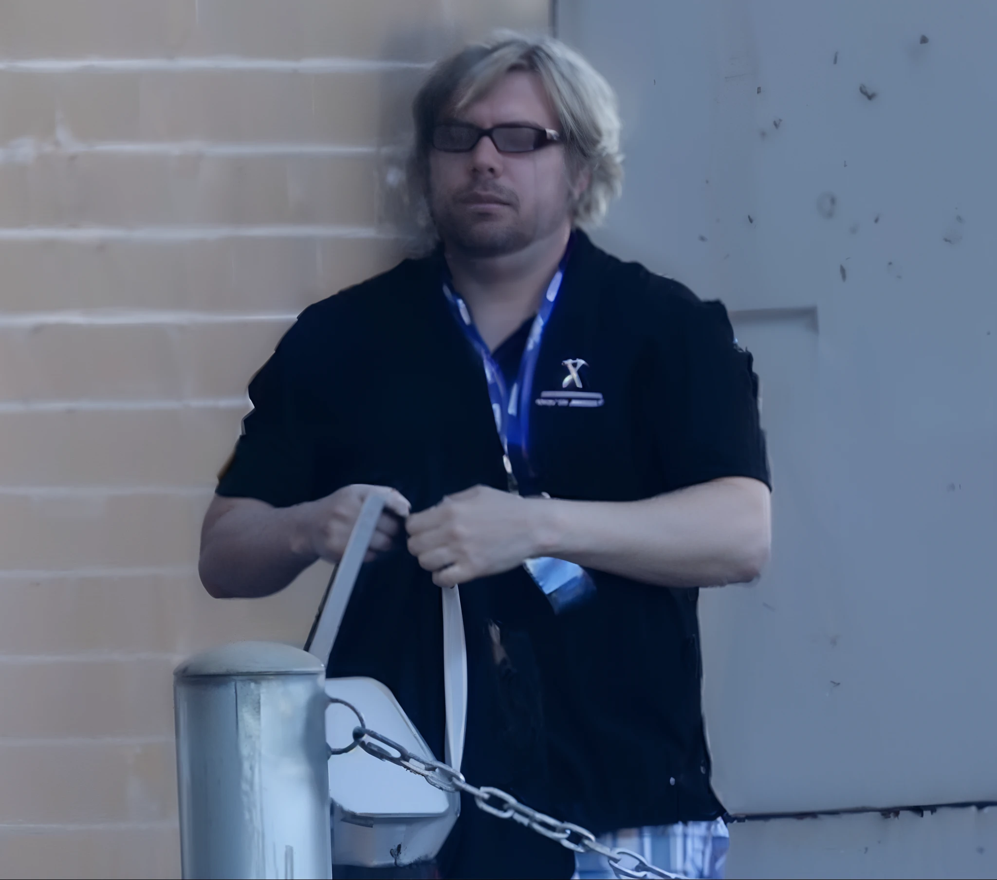 sharp focus photo of a man standing next to a metal poll with a chain connected to it, hig res, high resolution, clear