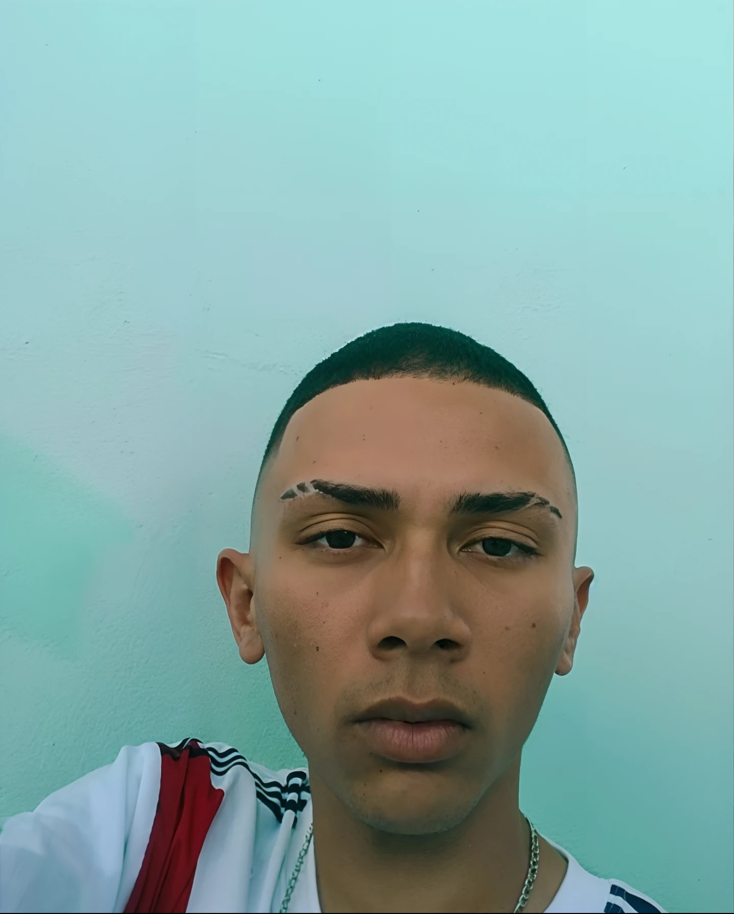 Arafed homem com uma camisa branca e uma camisa vermelha e branca, imagem frontal, em torno de 1 9 anos, taken in the early 2020s, corte buzz, Coelho ruim, andres rios, mostrando a testa, caio santos, Ronaldo Luis Nazario de Lima, shaved head, Ronaldo Luis Nazario da Lima, apenas testa, full head and shoulders