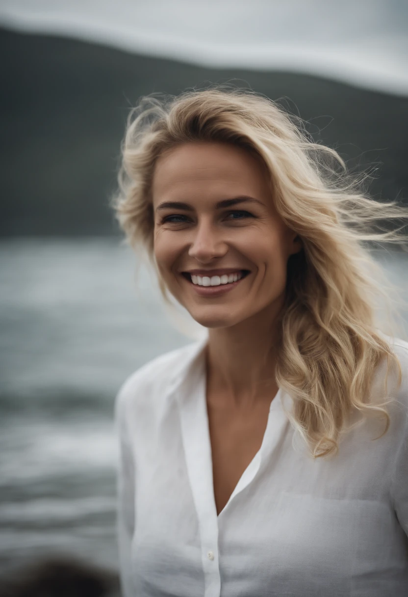 blonde woman with smile face and white linen shirt in the sea, hair collected, side portrait smiling, the sea in the background on a cloudy day with few rays of sun.