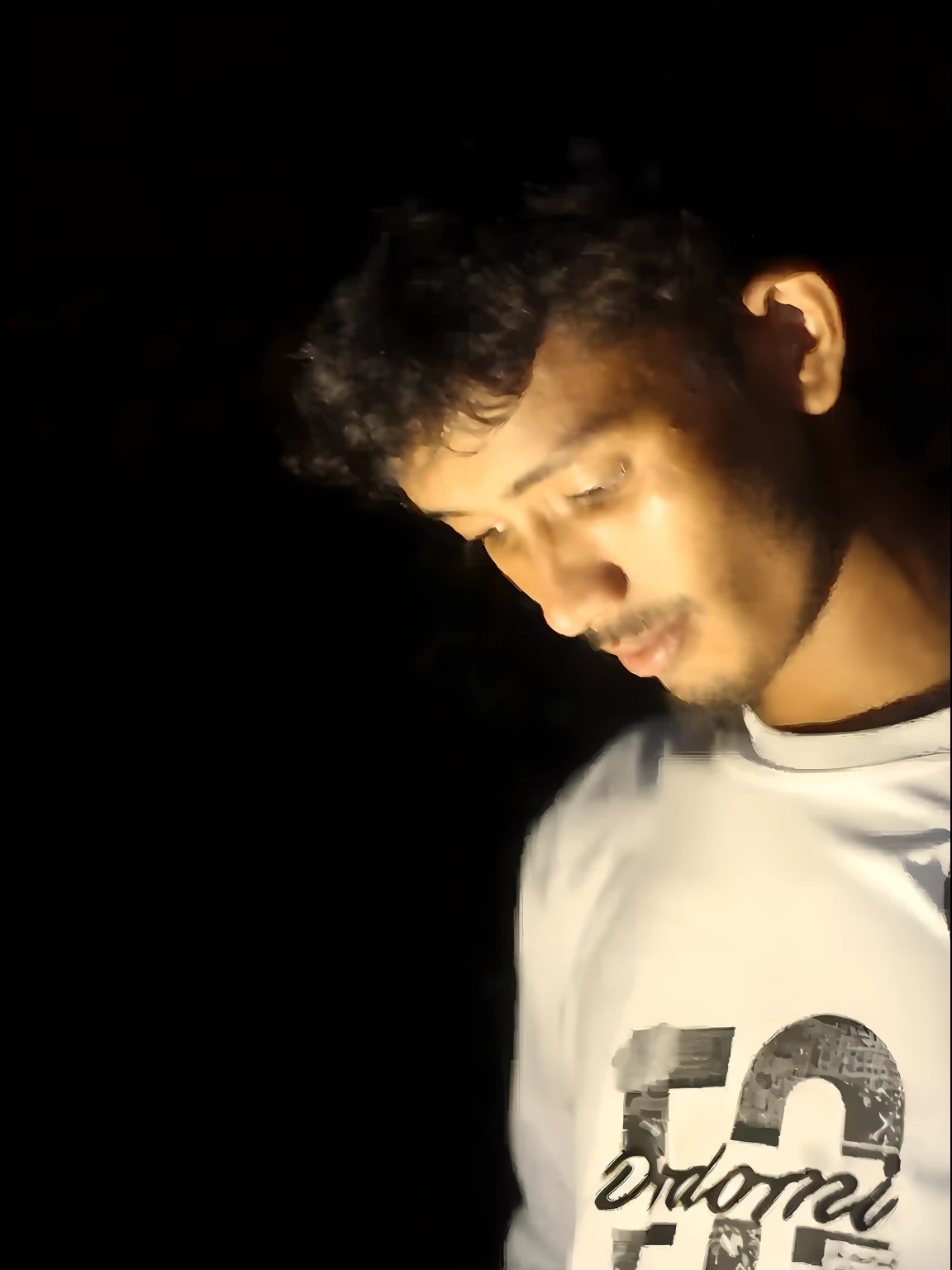arafed man looking at his cell phone in the dark, candid!! dark background, night time footage, style of ade santora, during night, (((low light))), with accurate face, mohamed chahin style, at night time, potrait, editorial footage, portraiit, at nighttime, low light photography, assamese aesthetic