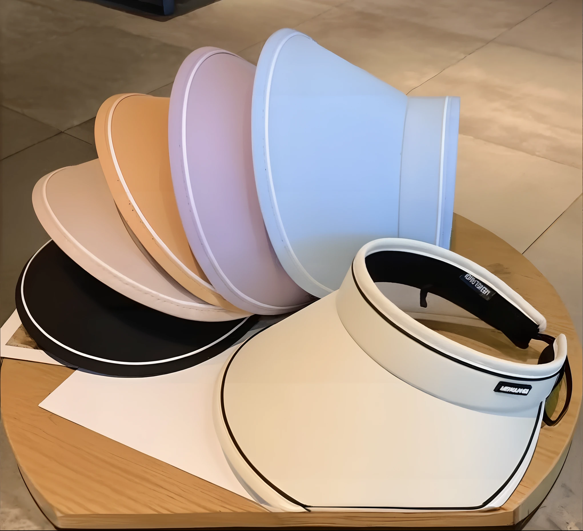 several different colored visor hats are stacked on a table, sleek visor, opaque visor, large opaque visor, various colors, reflective visor, pyramid visor, smooth transparent visor, iridescent visor, point of view of visor wearer, sleek blue visor for eyes, 3 colour, hand holding cap brim, multiple colors, gorget, round hood, 4 colors!!!