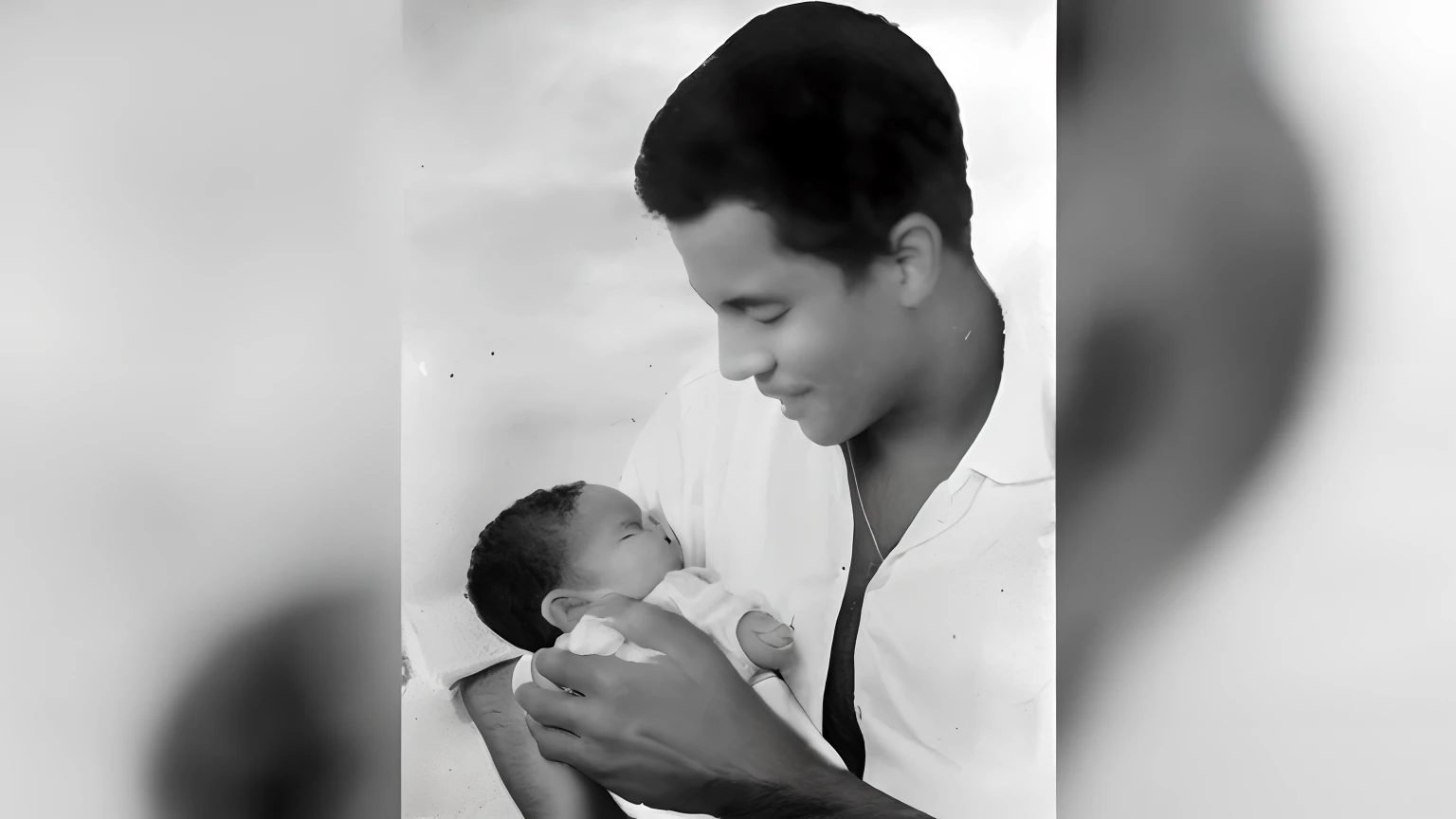 a black and white photo of a man holding a , pai com filho, mulato, with a kid,rected by: CeFerí Olivé, iconic shot, pai, por Gen Paul, fotografia rara, imagem real, untitled, Directed by: Emma Andijewska, Directed by: Paul Balkay, Jose Miguel Romano Francisca, Nascimento, Directed by: Leo Goetz