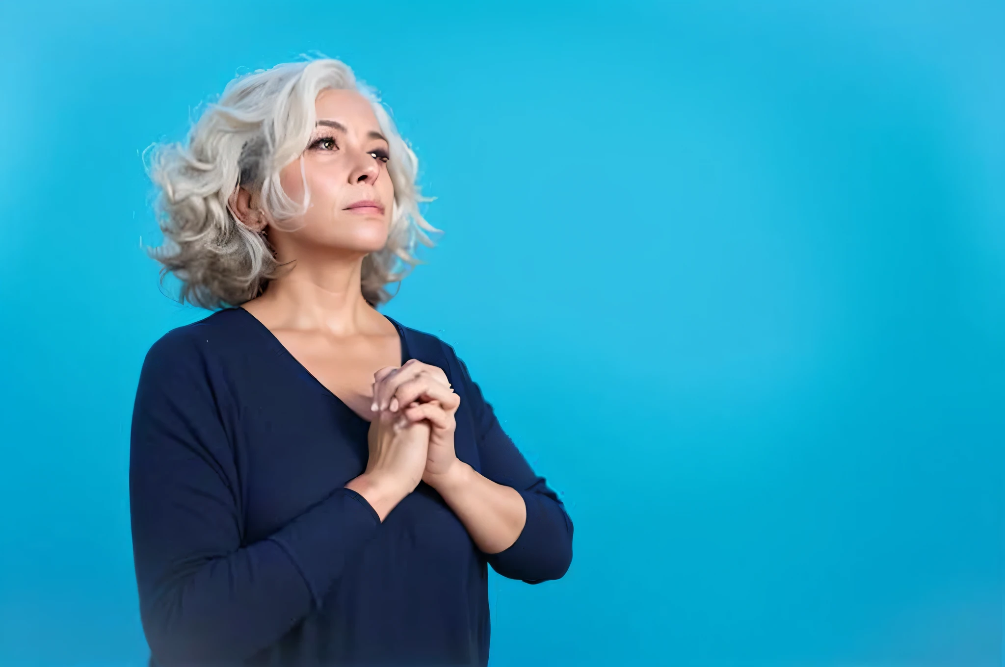 Retrato de uma mulher com cabelos grisalhos e uma camisa azul rezando, praying posture, com um fundo azul, pensive and hopeful expression, senhora de cabelos brancos, cabelos grisalhos, pose pensativa, ombro na frente pose, mulher de cabelo azul curto, contemplativo, mulher mais velha, doing a prayer, foto ainda, iStock, Directed by: Juan O'Gorman