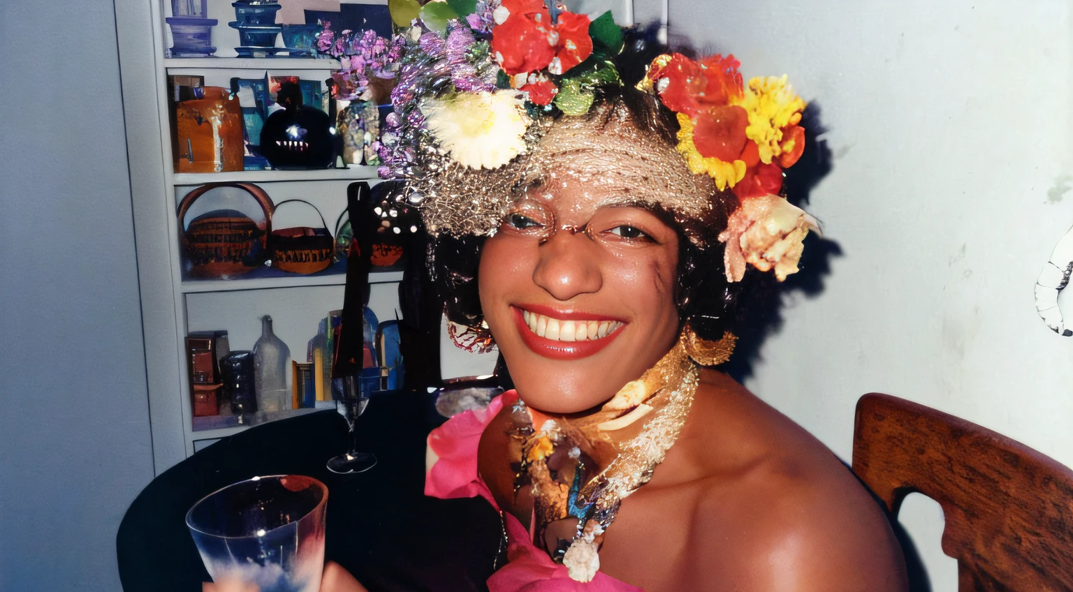 black woman sitting with glass in hand, flowers in her hair, strapless dress, happy smile, realistic smiling, highly realistic, with strong colors, photography, Marsha p johnson image, stonewall