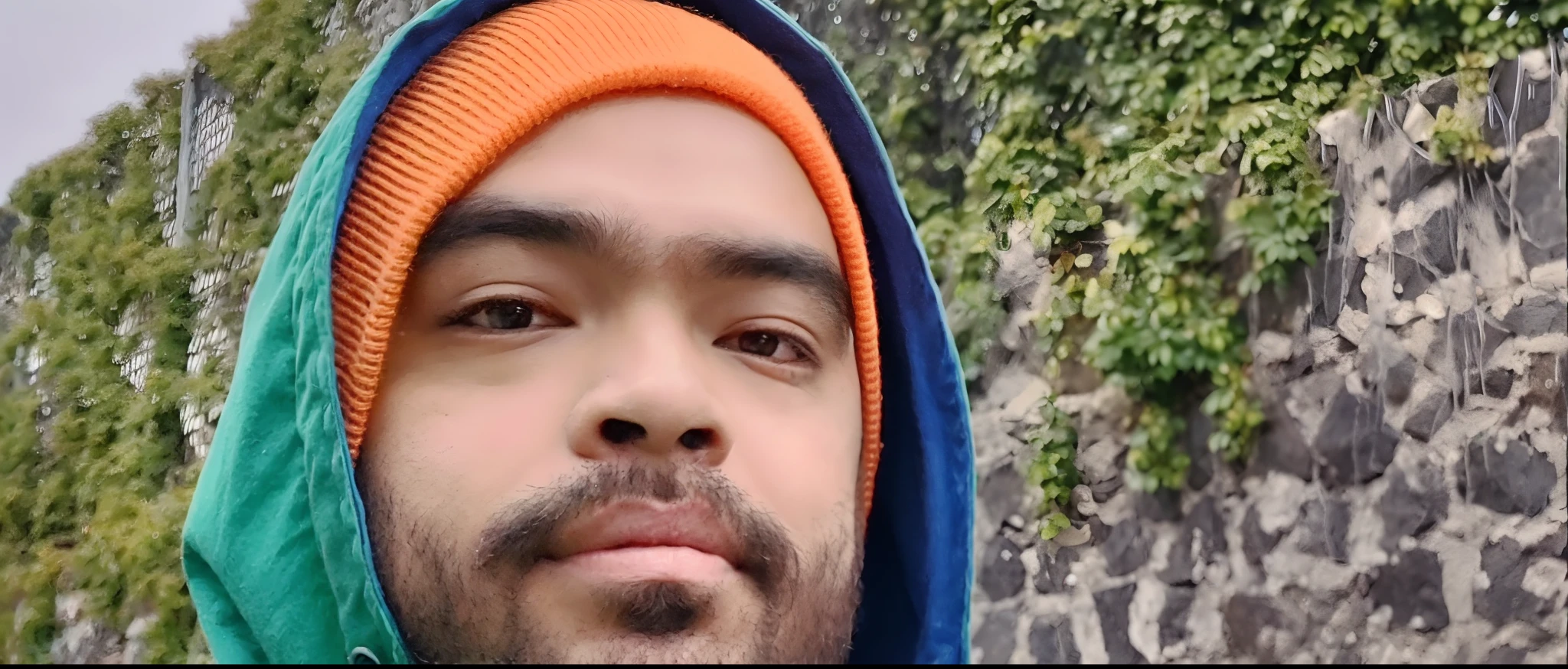 Arafed Hombre con sudadera con capucha verde y sombrero naranja, imagen de muy muy muy baja calidad, inspirado por Kailash Chandra Meher, foto de perfil 1024px, Fanart, Foto de baja calidad, Retrato disparado 8K, with mountains as background, album photo, Retrato a mitad de plano, Tomada en iPhone 14 Pro, with mountains in the background, !! bajo contraste!!