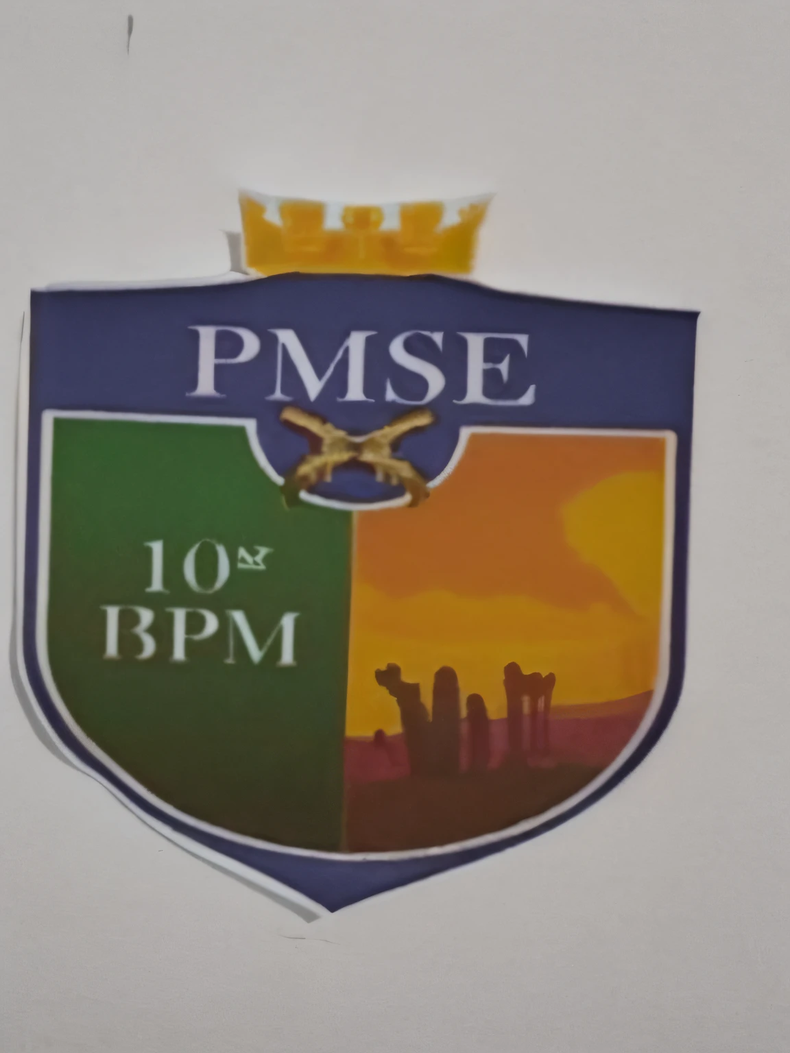Coat of arms of PMSE divided into two sides. Em um lado a core verde escrito 10BPM. Outro lado da cor amarela um deserto.