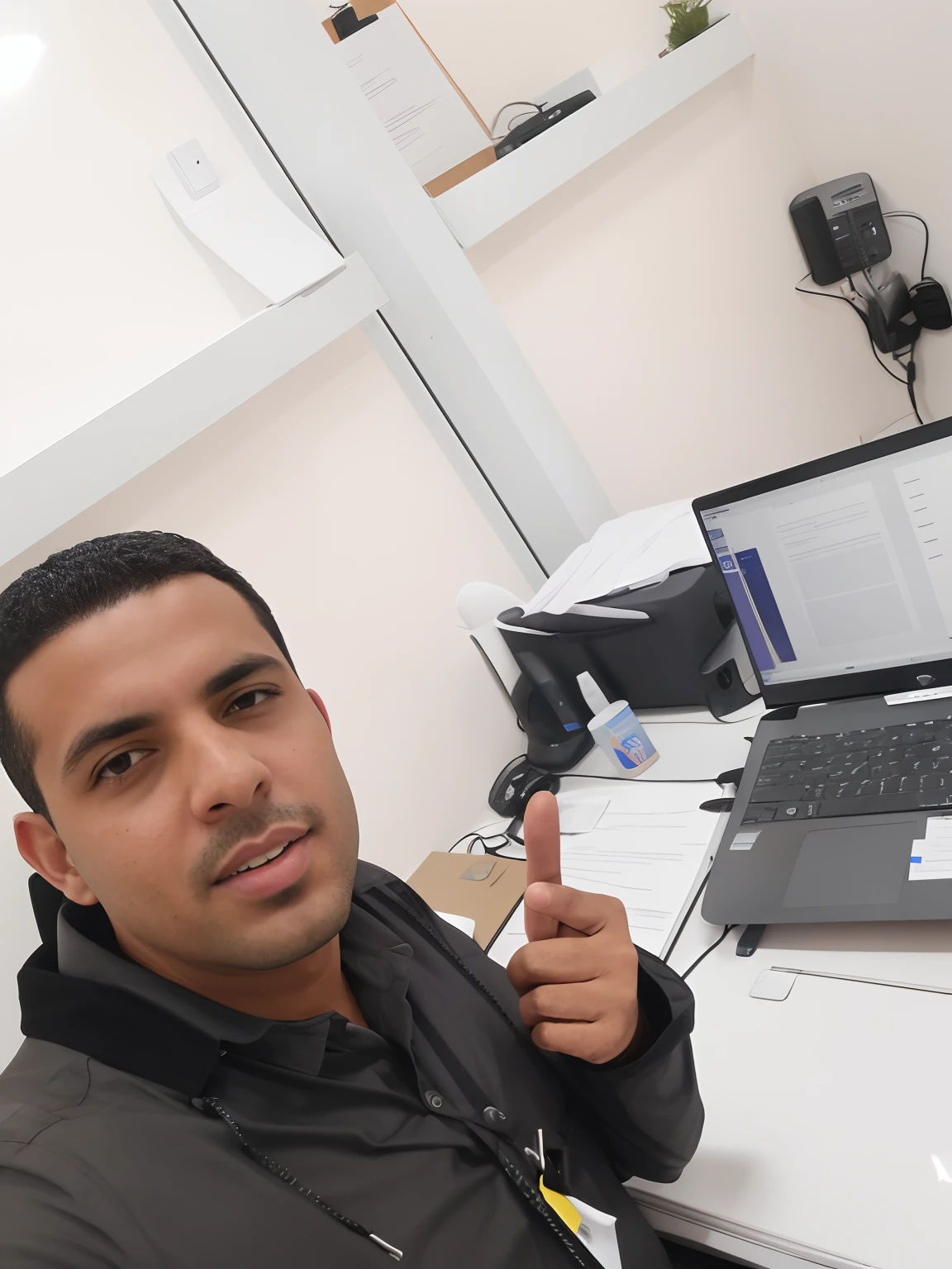There's a man sitting at a desk with a laptop and a cell phone, at office, in office, working in an office, sentado no cargo, Alex, na frente de um computador, Mohamed Chahin, in an office, imagem de qualidade muito baixa, in an call centre office, Riyahd Cassiem, Mohamed Reda
