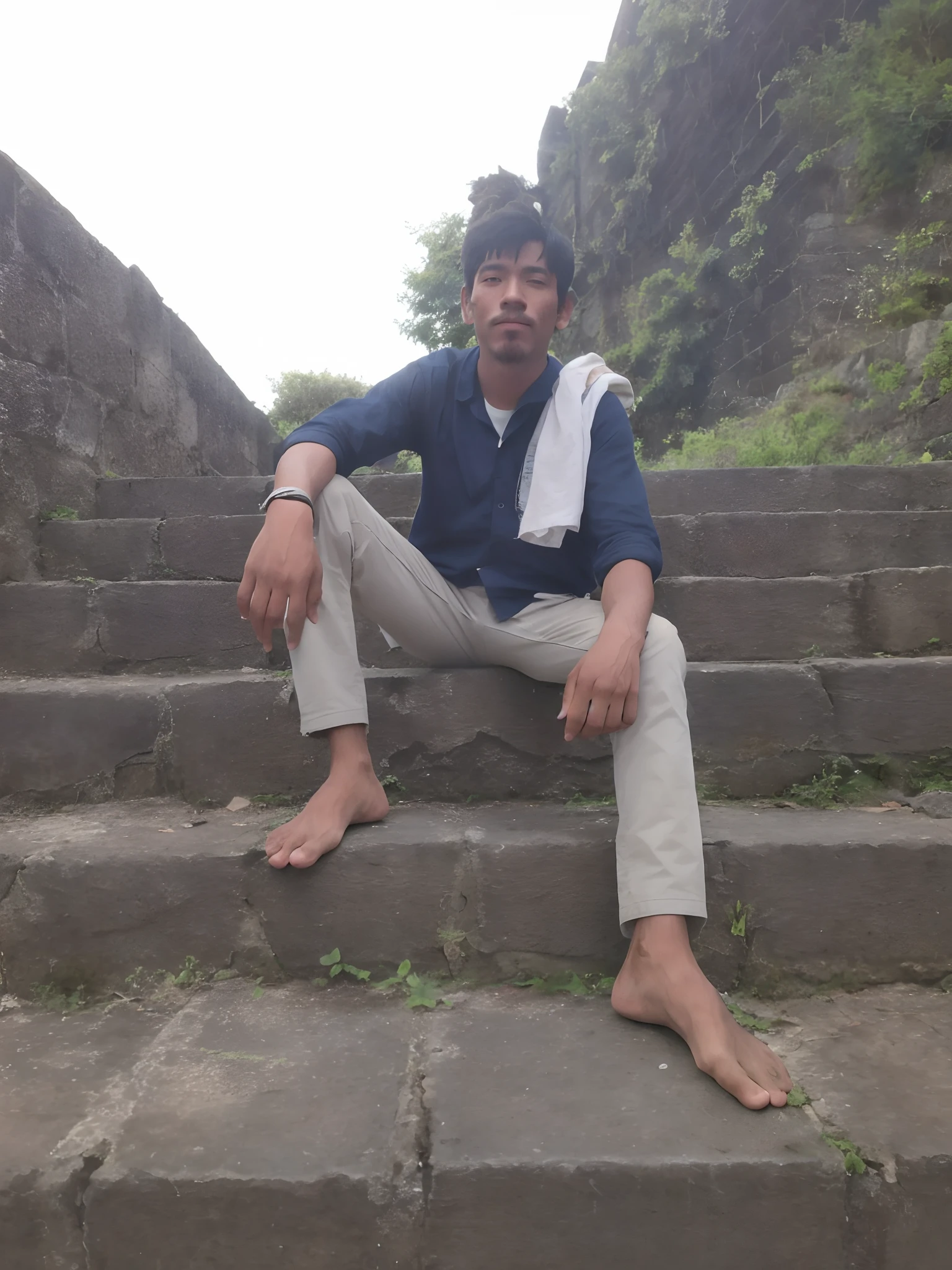there is a man sitting on the steps of a stone stairway, sitting on temple stairs, very very low quality picture, at an ancient city, sitting on the ground, very artistic pose, candid picture, with a cool pose, connected with hanging bridge!!, with lovely look, cool pose, in front of a temple, at college, sitting under bridge, ayan nag