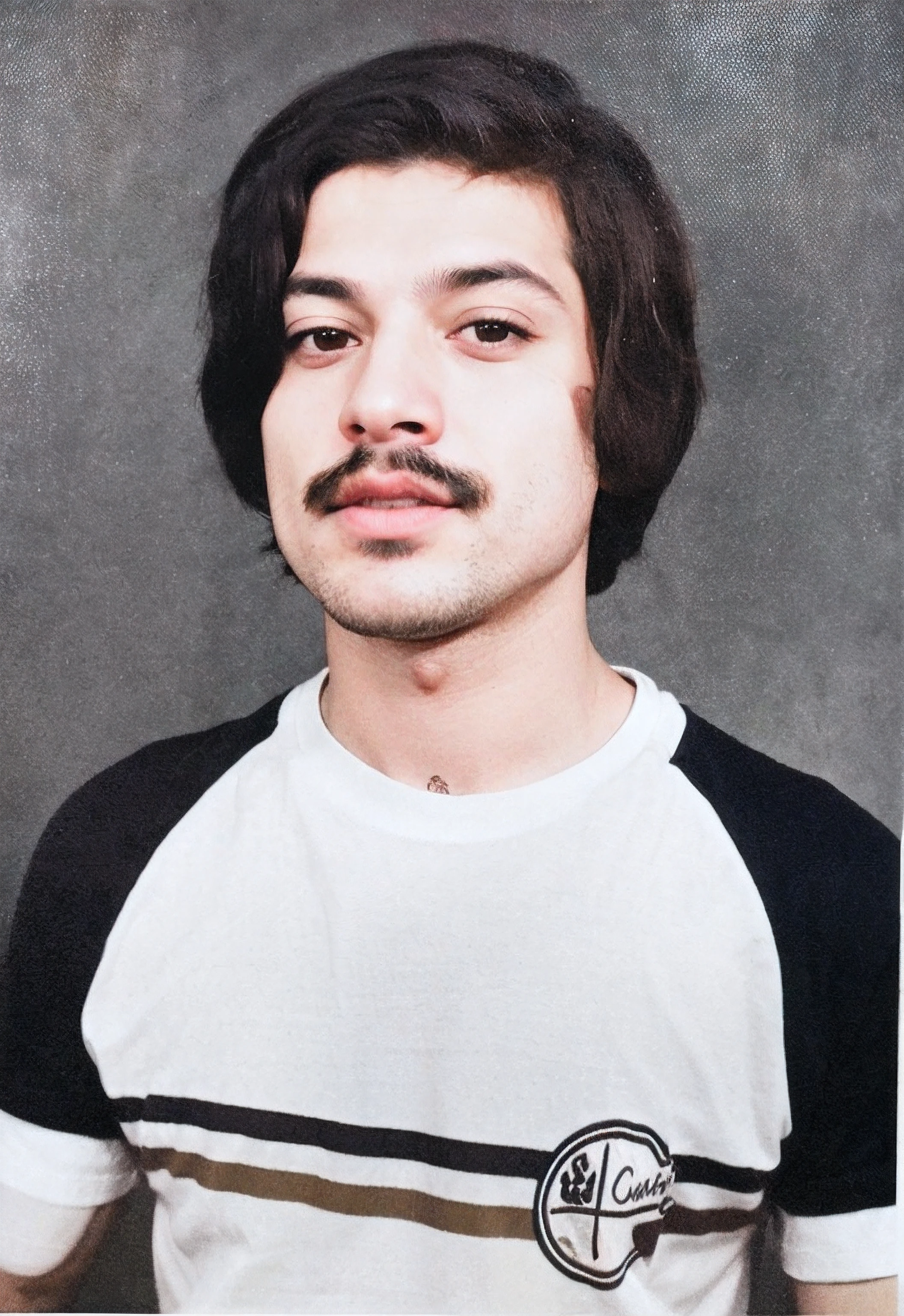Foto de um homem com bigode preto, retrato colorido, homem com cabelo comprido de cor preta, olhos pretos, tshirt branca e preta com uma linha preta e uma linha castanha, tshirt de manga curta, pele clara, fundo cinzento, raw photo, amazing photograph, best quality, 8K, high quality, Ultra detailed, (best quality), (high detailed skin, full sharp:1.2), 8k uhd, dslr, detailed face