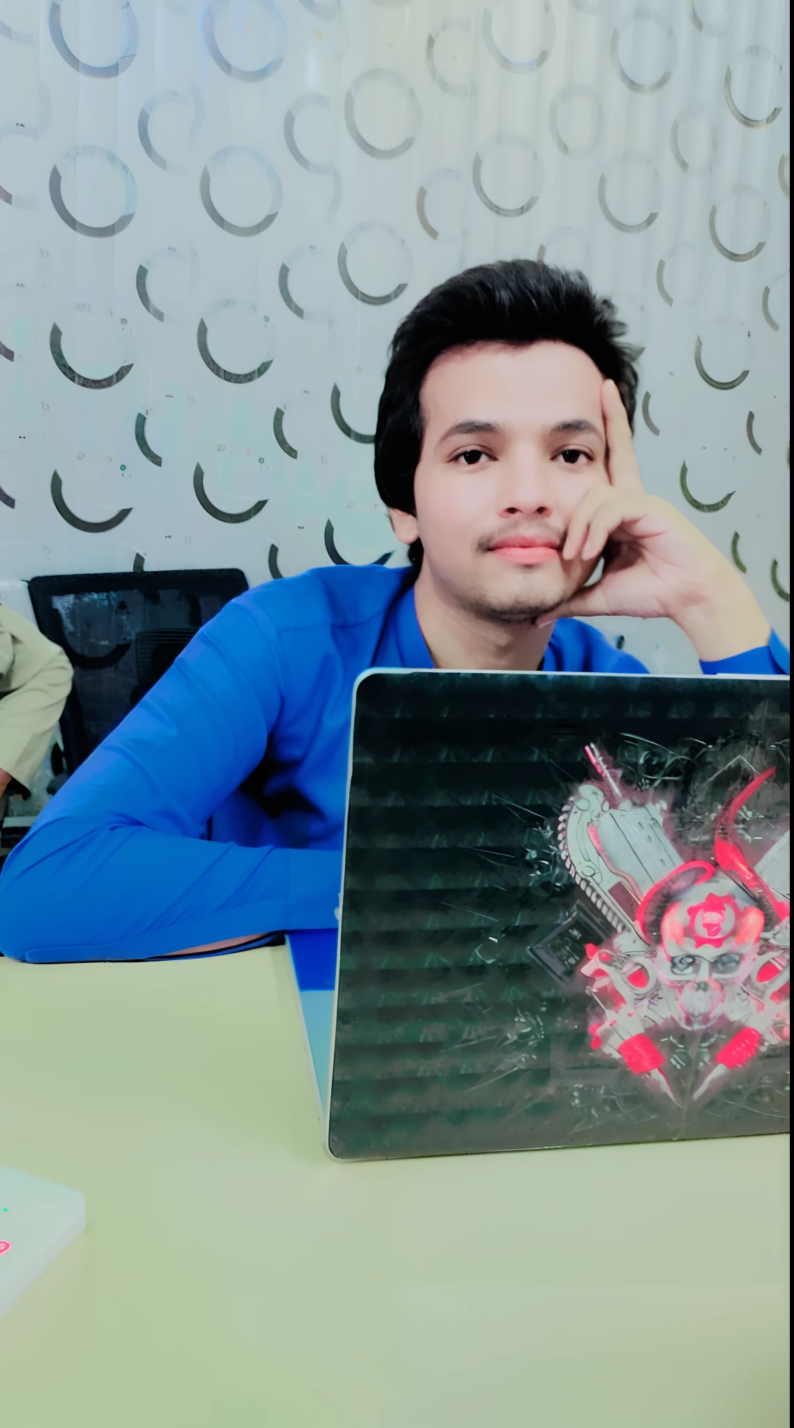 there is a man sitting at a table with a laptop computer, mohamed chahin, khyzyl saleem, mohamed chahin style, profile picture 1024px, kyza saleem, ash thorp khyzyl saleem, very very low quality picture, profile pic, riyahd cassiem, with accurate face, very artistic pose
