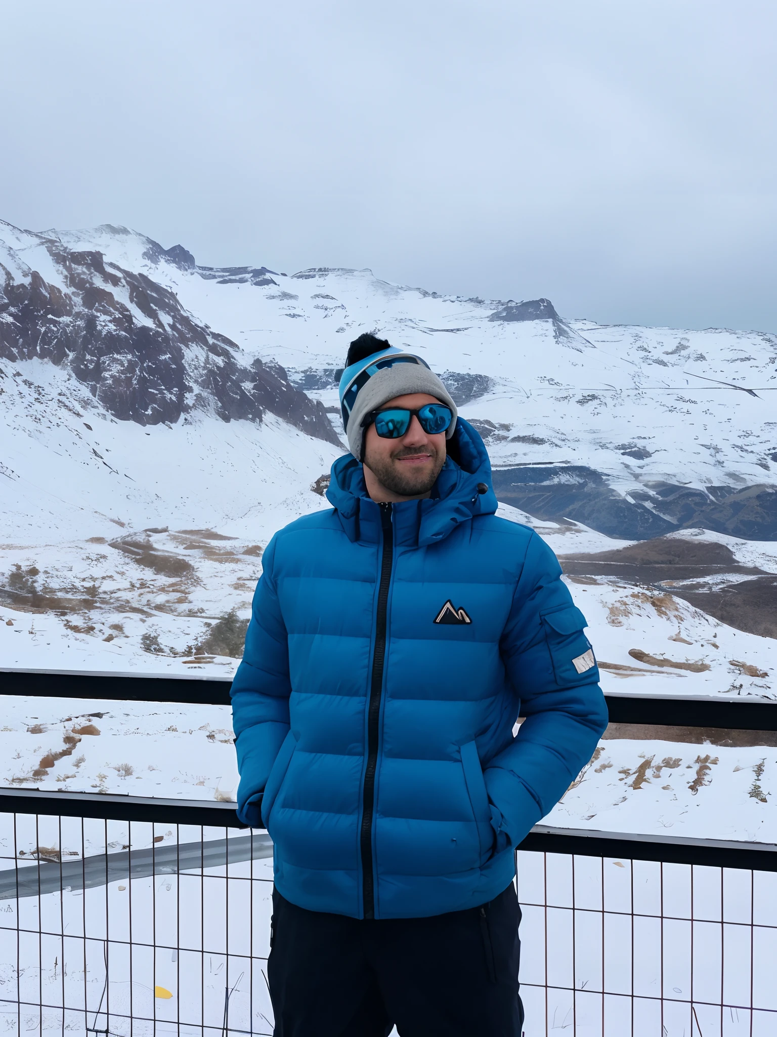 arafed man in blue jacket and hat standing on a snowy hill, with mountains in the background, with mountains in background, with mountains as background, cold as ice! 🧊, mountains in the background, epic mountains in the background, in the mountains, in the snow mountains, andes, in mountains, icy mountains in the background, high in the mountains