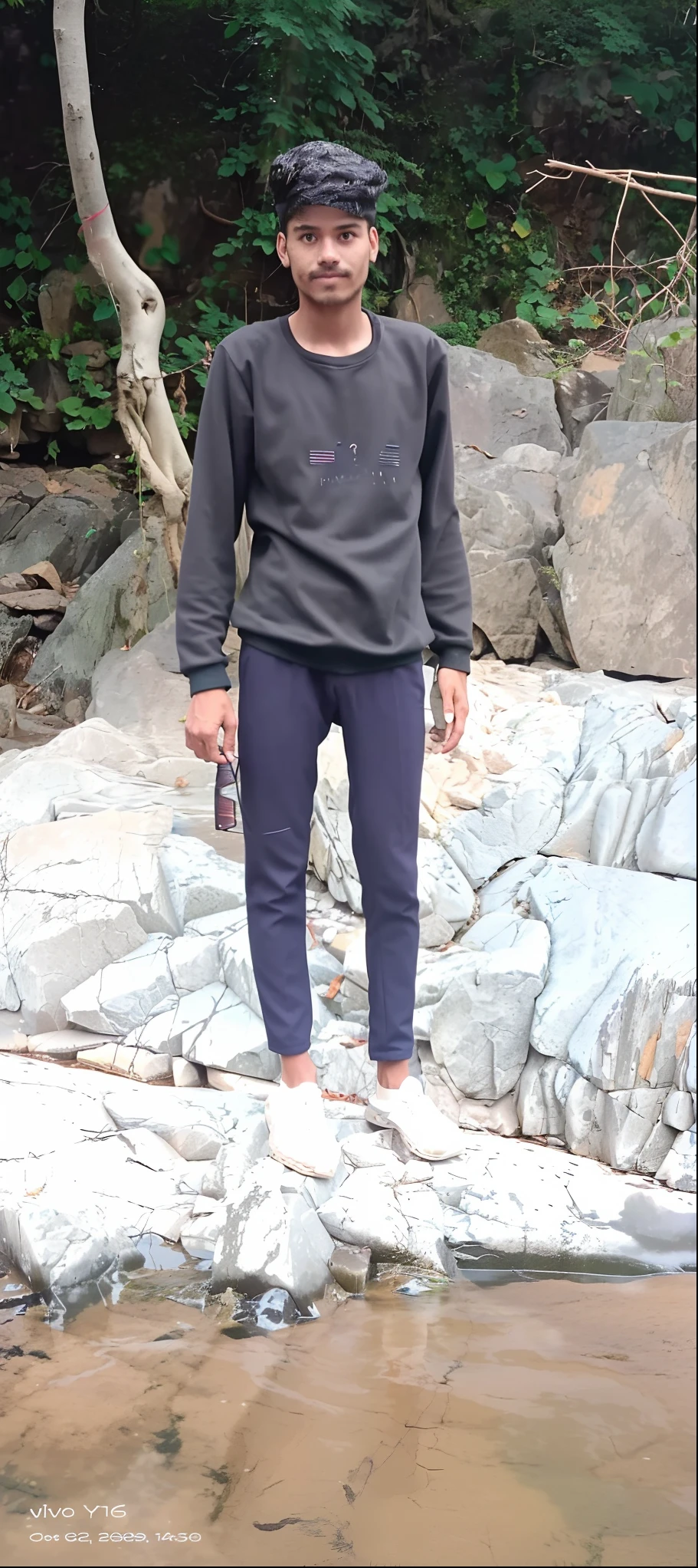 there is a man standing on a rock in the water, full body picture, standing on rocky ground, full body profile camera shot, full body photogenic shot, wearing only pants, distant full body view, full body potrait holding bottle, distant full body shot, zoomed out full body, full body pictures, standing pose on stones, standing in 🛣️