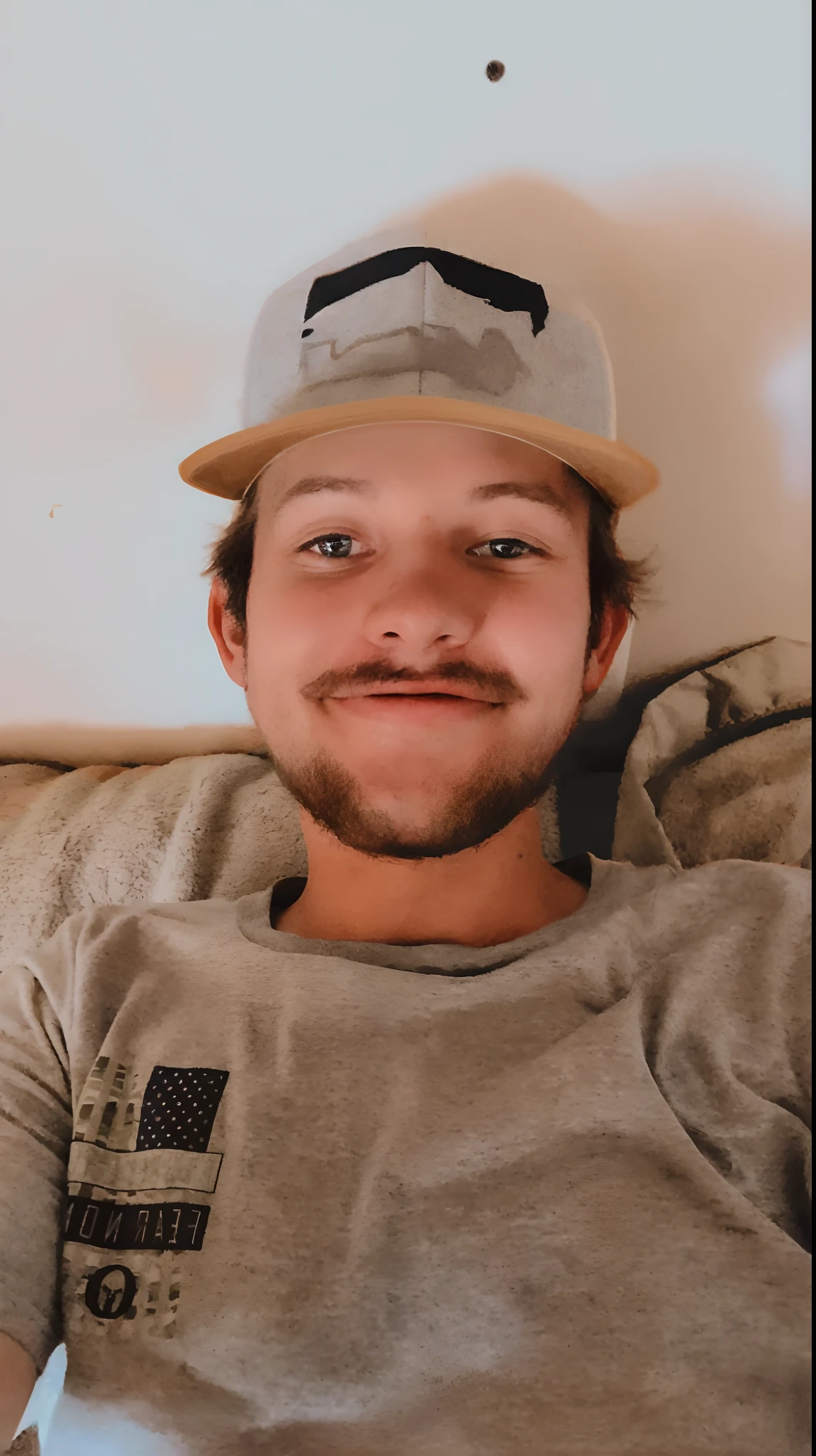 arafed man with a hat on laying on a couch, twitch streamer / gamer ludwig, smiling and looking directly, it's wearing a cute little hat, he is wearing a hat, good looking face, goofy smile, halfbody headshot, smirking at the camera, headshot profile picture, 22 years old, almost smiling, very slightly smiling