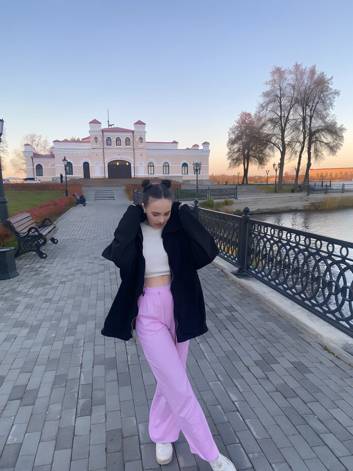 A woman in pink pants with a tie walks along a brick path, in the city park, The style of Yulia Razumova, ekaterina, dasha taran, in park, 8K)), with sunset, with a figure in the background, vibrant aesthetic, Beautiful aesthetics, In the center of the city, In front of the house