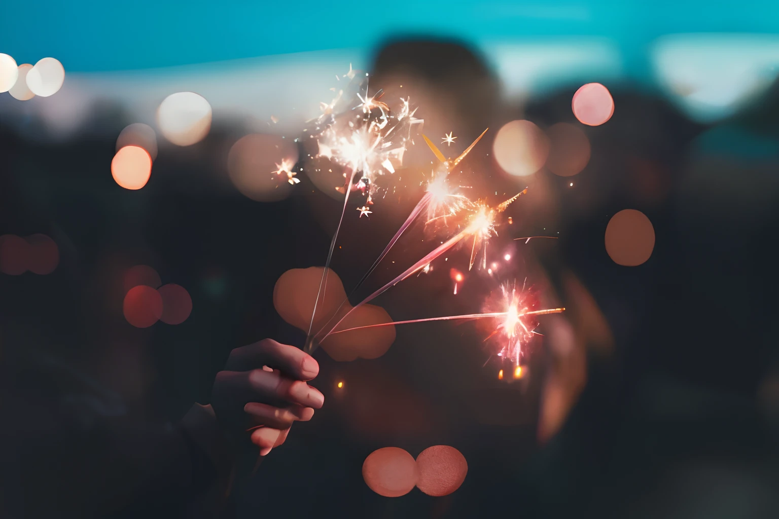 Someone holding a sparkler in their hand with a blurred background, Cierge, Brandon Woelfel, magic sparkles, Sparks in the air, Sparks of Fire, with lots of flickering light, Flying sparks, Sparks, fireworks, feu d'artifice, Bright sparks, Sparks, light sparkles, Sparks of Light, Sparks, celebrating, Pexels, Fireworks in the background
