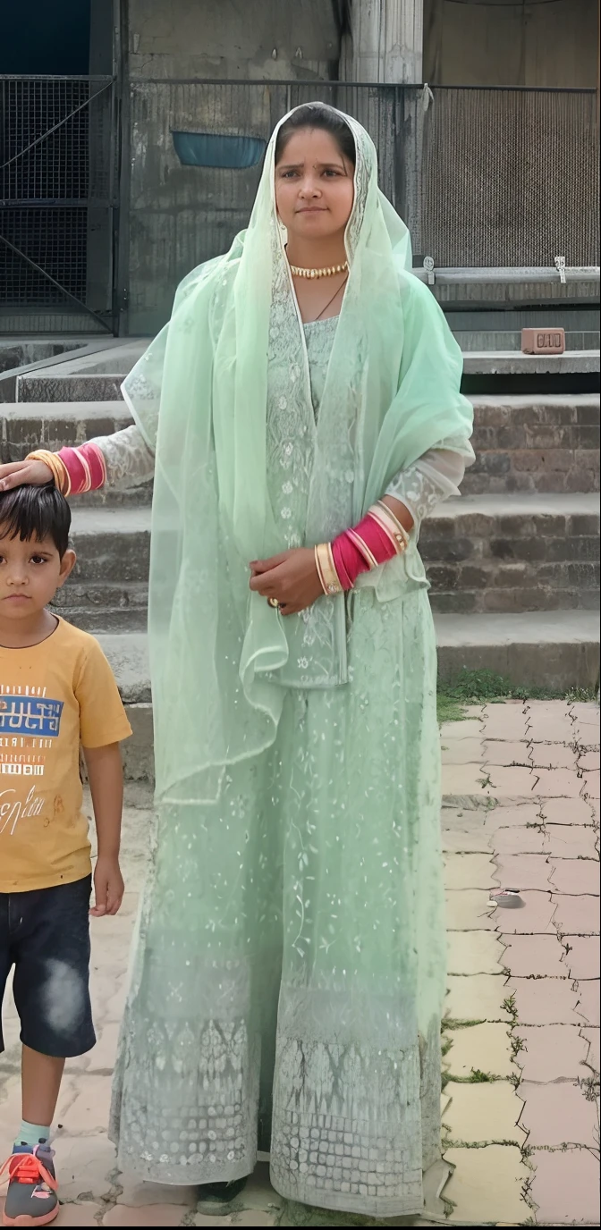 there is a woman and a standing in front of a building, by Manjit Bawa, very very low quality picture, very clear picture, with a kid, wearing traditional garb, 3 0 years old woman, 30 years old woman, traditional dress, candid picture, wearing a kurta, gown, full body in camera, wearing authentic attire