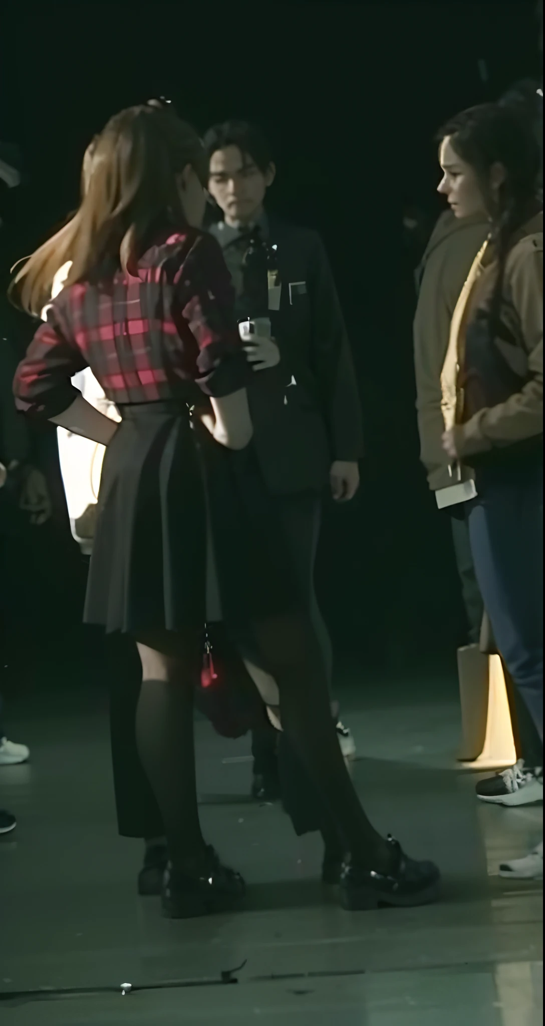 multiple people, standing in line in a dark room, dancing in the background, girl at a fashion show in hell, Set photo in costume, hugging her knees, There's a scary atmosphere behind it, very accurate photo, zoomed out shot, Fashion Show Photos, on the runway, dressed as schoolgirl, On the set, candid shot, Rear view photo