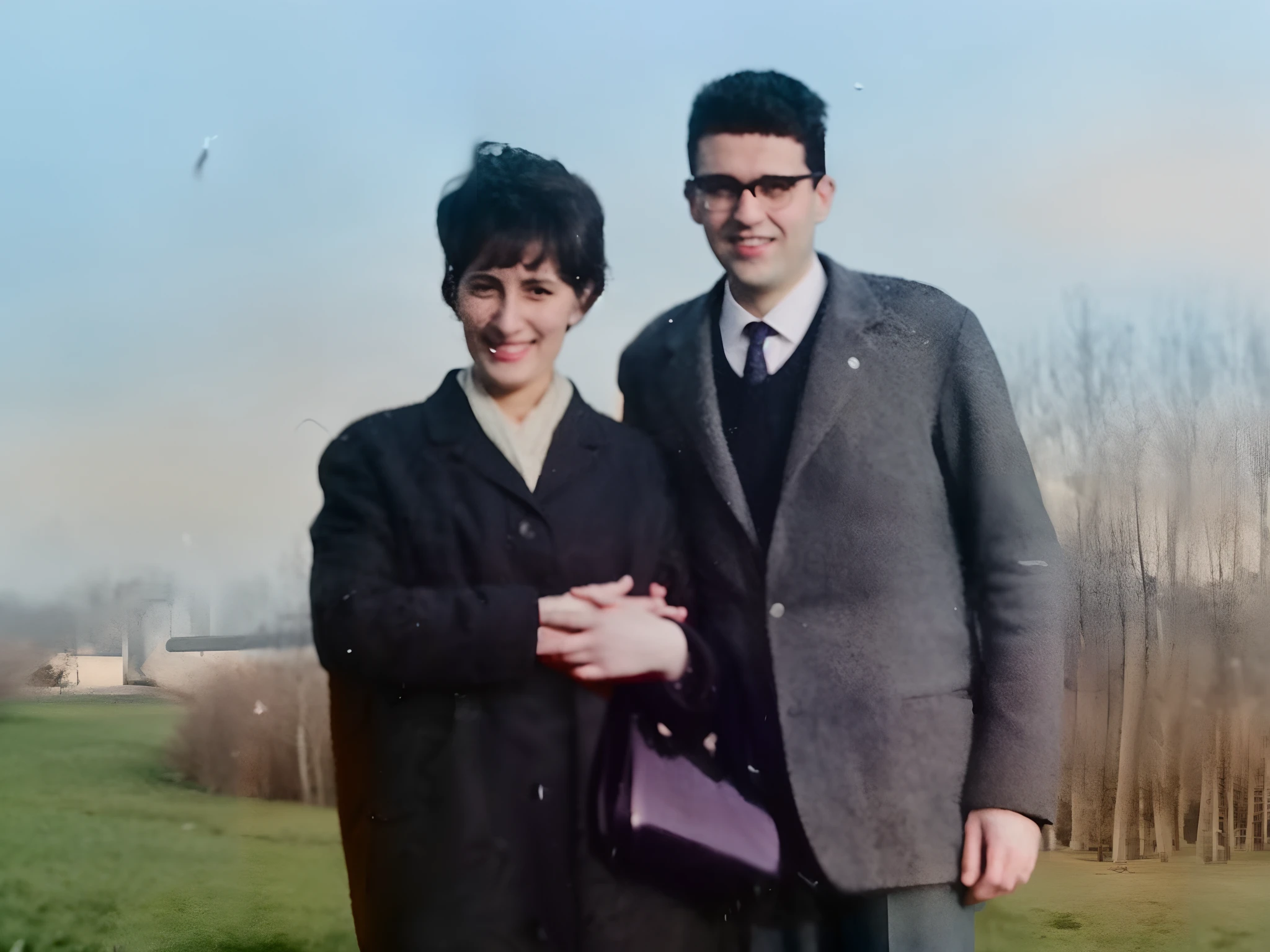 Couple standing in a park, smiling, winter