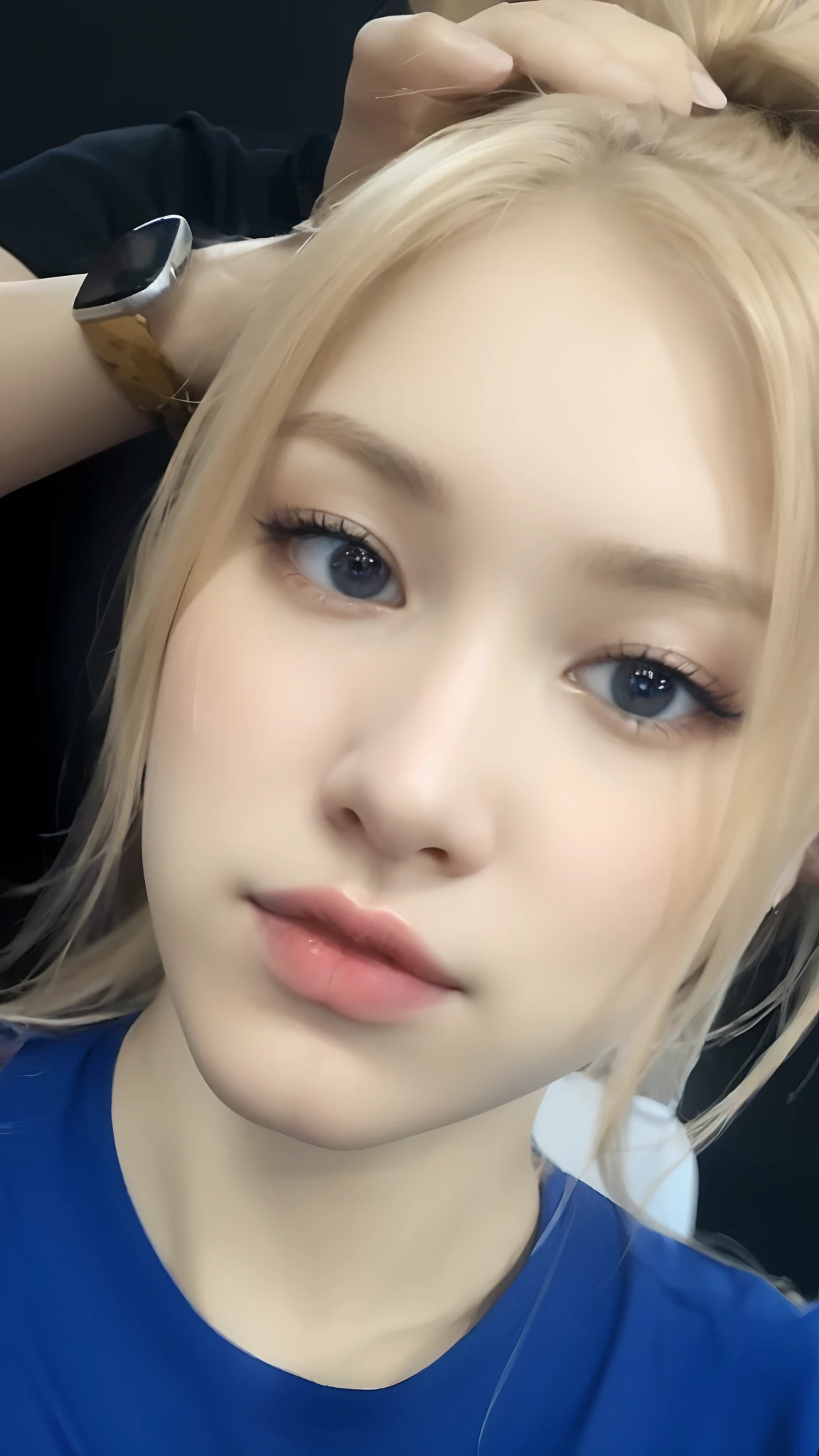 chica rubia de ojos oscuros, camiseta azul, haciendo mueca