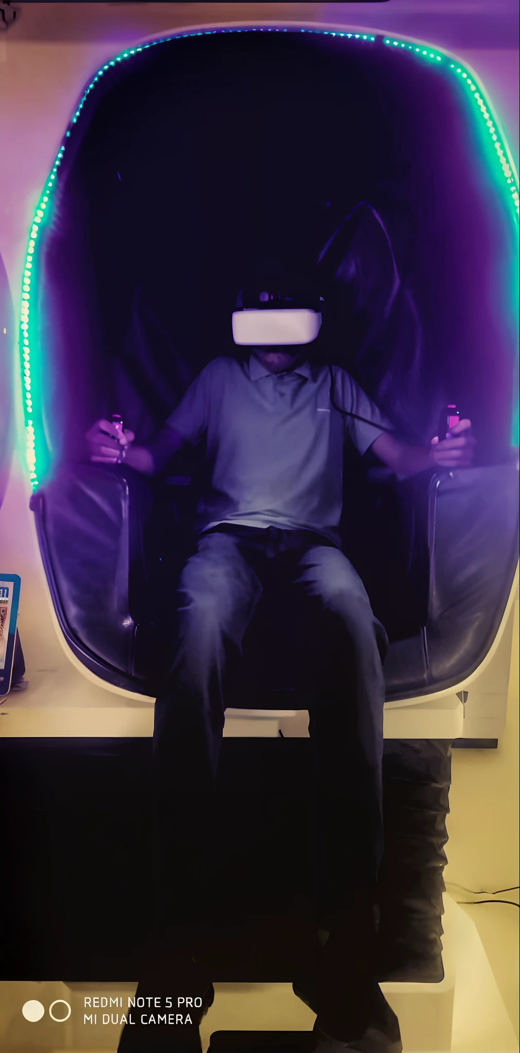 there is a man sitting in a chair with a virtual reality device on it, vr game, virtual reality, wearing vr, vr helmet on man, using a vr headset, wearing a vr-headset, wearing a vr headset, virtual metaverse room, vr helmet, wearing vr goggles, vr goggles, deeper into the metaverse we go, 3d video game.Convert in cyberpunk handsome boy. Technology. Mechanical