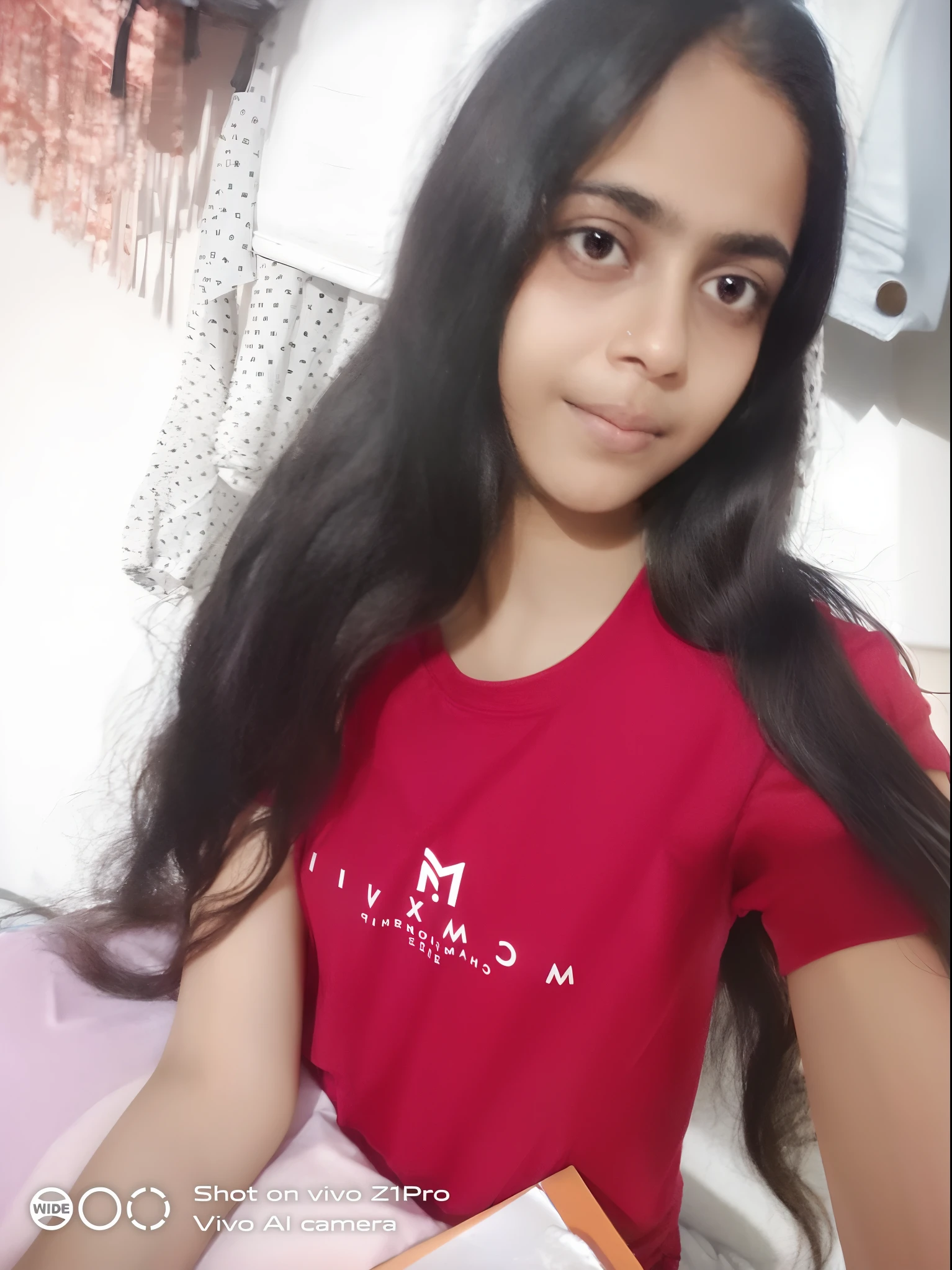 arafed girl with long black hair sitting on a bed, in tshirt, long hair and red shirt, with long hair, 18 years old, 1 6 , with a beautifull smile, wearing in shirt, with long dark hair, frontal picture, young teen, morning time, friedly smile, by Maria Helena Vieira da Silva