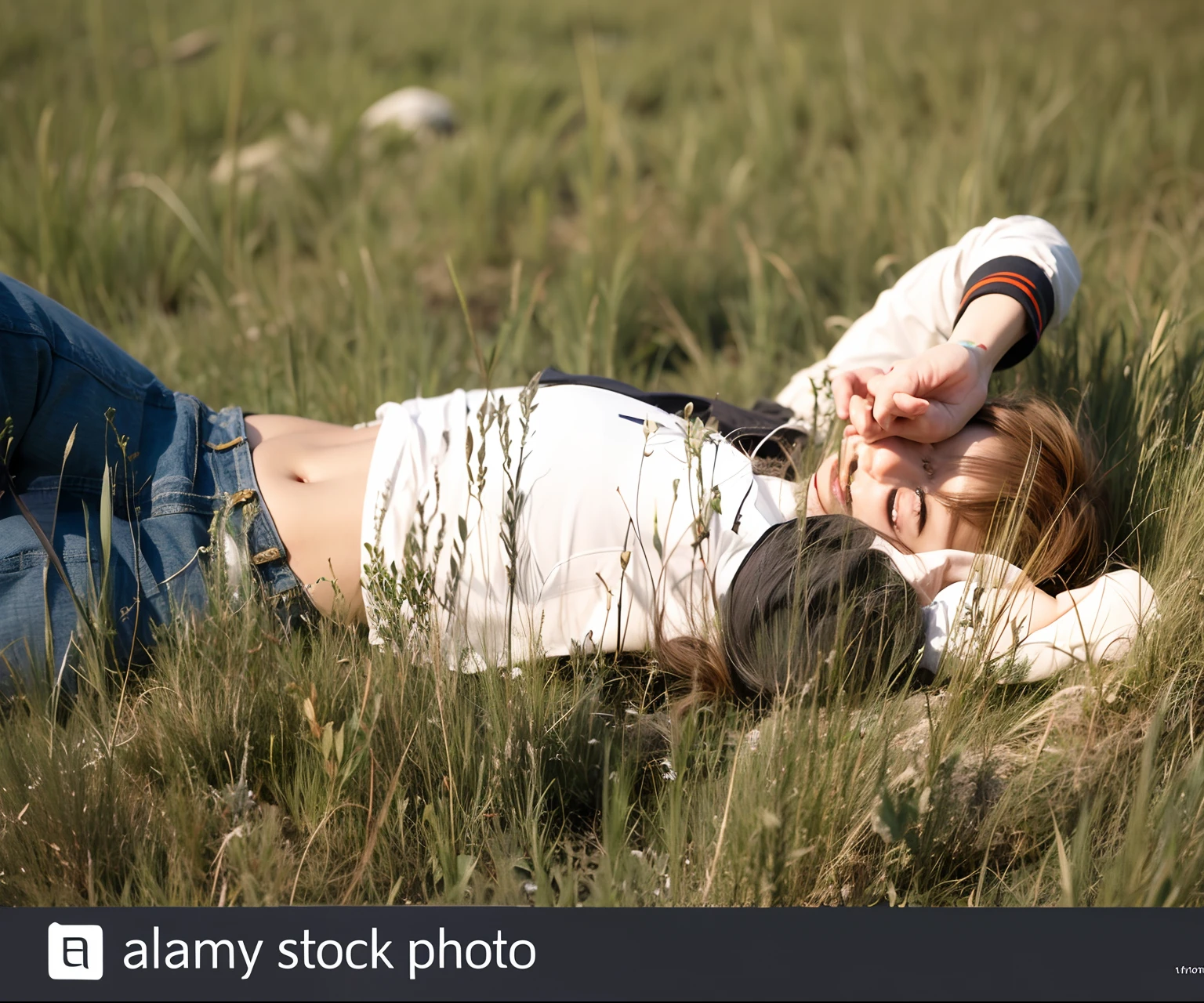 A boy lying on grass with hand on his face