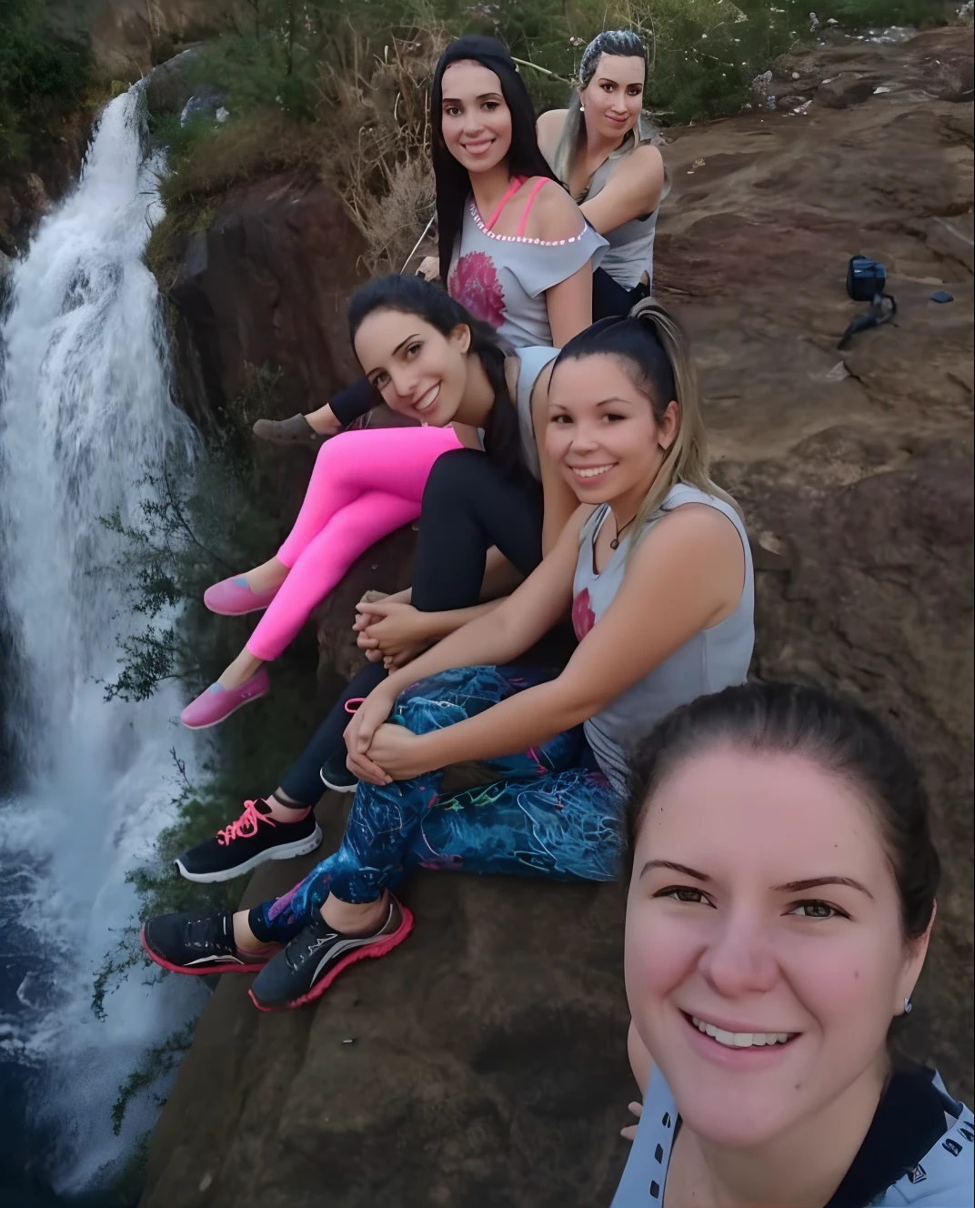 Several women sitting on a rock near a waterfall and a waterfall, cachoeiras ao fundo, ao lado de uma cachoeira, com uma cachoeira, com cachoeiras, cachoeira ao fundo, waterfall!!!!!, standing near a waterfall, com cachoeiras e rio, Directed by: Nandor Soldier, em uma caverna com a cachoeira, em frente a uma cachoeira, foto de grupo estilo pixar