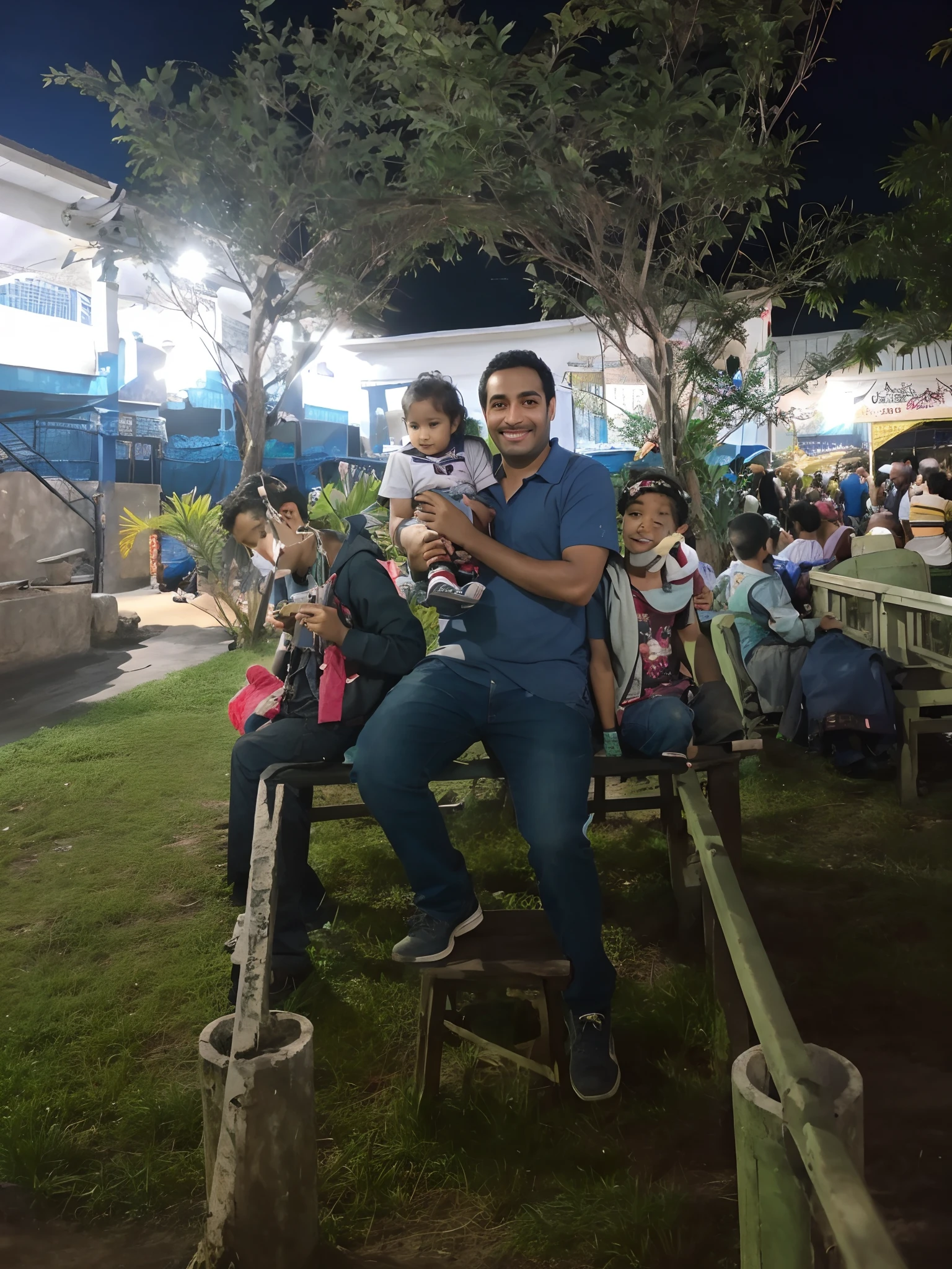 There is a man and a child sitting on a bench, with a kid, photo taken at night, imagem de qualidade muito baixa, Mohamed Reda, divertindo-se, Alex, Mohamed Chahin, No Egito, foto modo retrato, Sucot, Amr Elshamy, non blurry, Emad Mostaque, An amusement park in Ancient Egypt