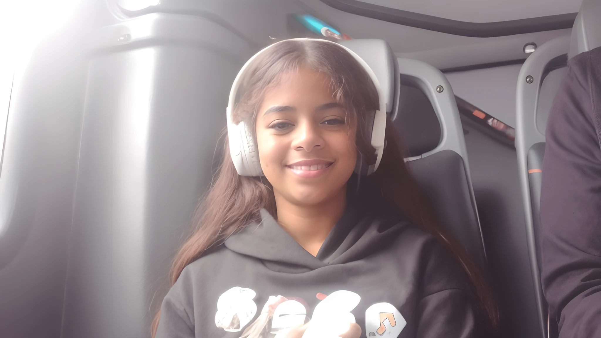 There's a young woman sitting on a bus with headphones on, Riyahd Cassiem, com fones de ouvido, menina usando fones de ouvido, menina de cabelo preto vestindo capuz, com fones de ouvido, Violeta Myers, Taliyah Jovem, Alanis Guillen, sentada em seu carro, usando um fone de ouvido, taken in the early 2020s, Usando fones de ouvido