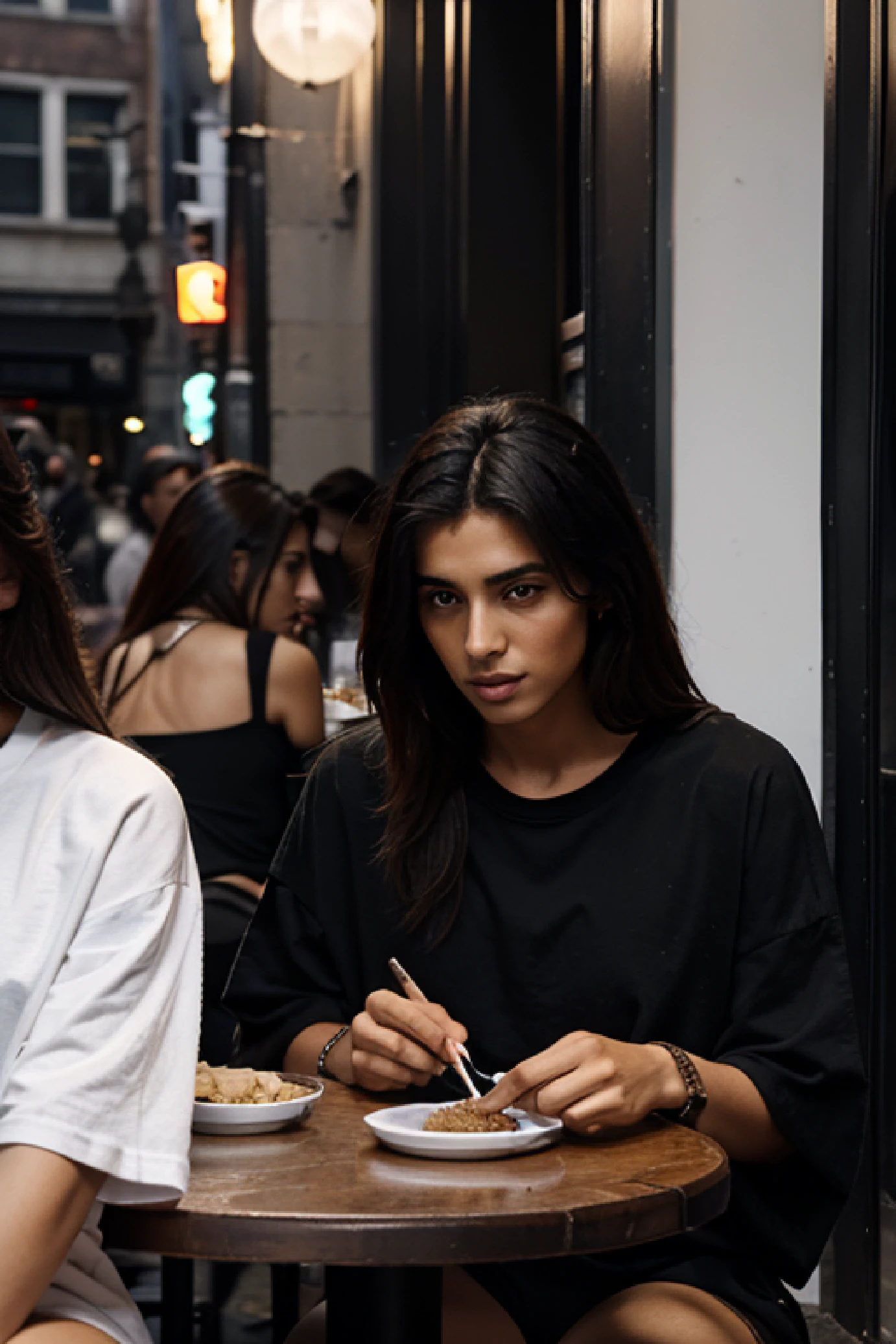 group of middleeastern models sitting to eat in soho NYC, wearing fear of god style streetwear, loose, oversized t-shirt