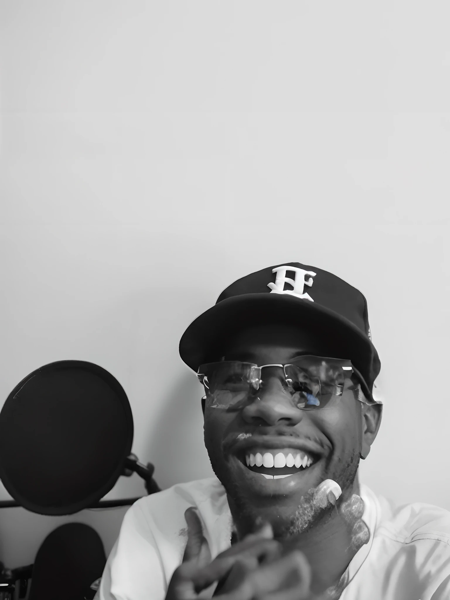 Smiling man in a baseball cap and glasses sitting in front of a microphone, Rap, feliz com a boca aberta, rap no microfone, dessaturados!!, with rap cap on head, Rindo muito, sorrindo timidamente, sorriso largo, mid riff, dessaturados!, por mckadesinsanity, 1 / 2 headshot, he's smiling, smiling at camera