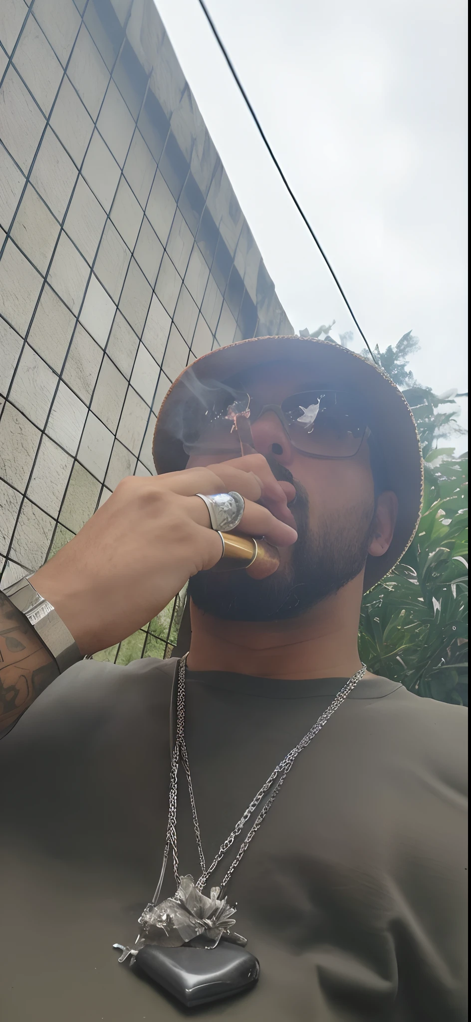 There's a man with a hat and a necklace smoking a cigarette, com charuto, enquanto fuma um charuto, Fumar uma cigarrette🚬, fazer uma pausa para fumar, fumar um charuto grosso, fumar fora, subject action: fumar um charuto, fumar com pose de agachamento, Fumar um charuto grande, segurando charuto, fumar um charuto, fora sozinho fumando maconha, charutos para fumar