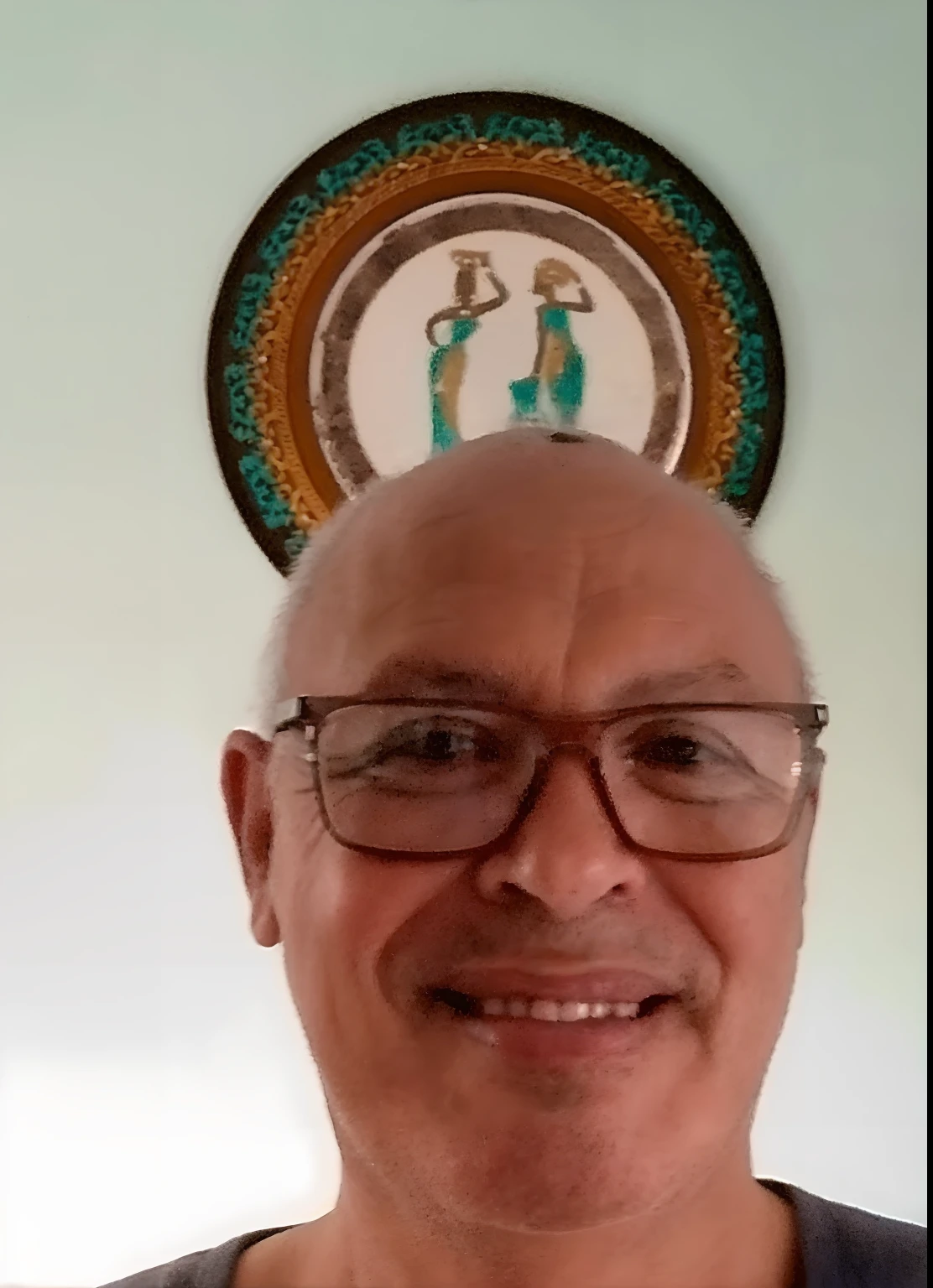 Smiling man with glasses and a plate on the wall above him, VOTO PACAL, david rios ferreira, Arauto Ortega, Anthony J. Manzanedo, Ricardo Taddei, George Doutsiopoulos, taken in the early 2020s, Salustiano Garcia Cruz, Ricardo Sigamani, victor maristane, henry ascensio