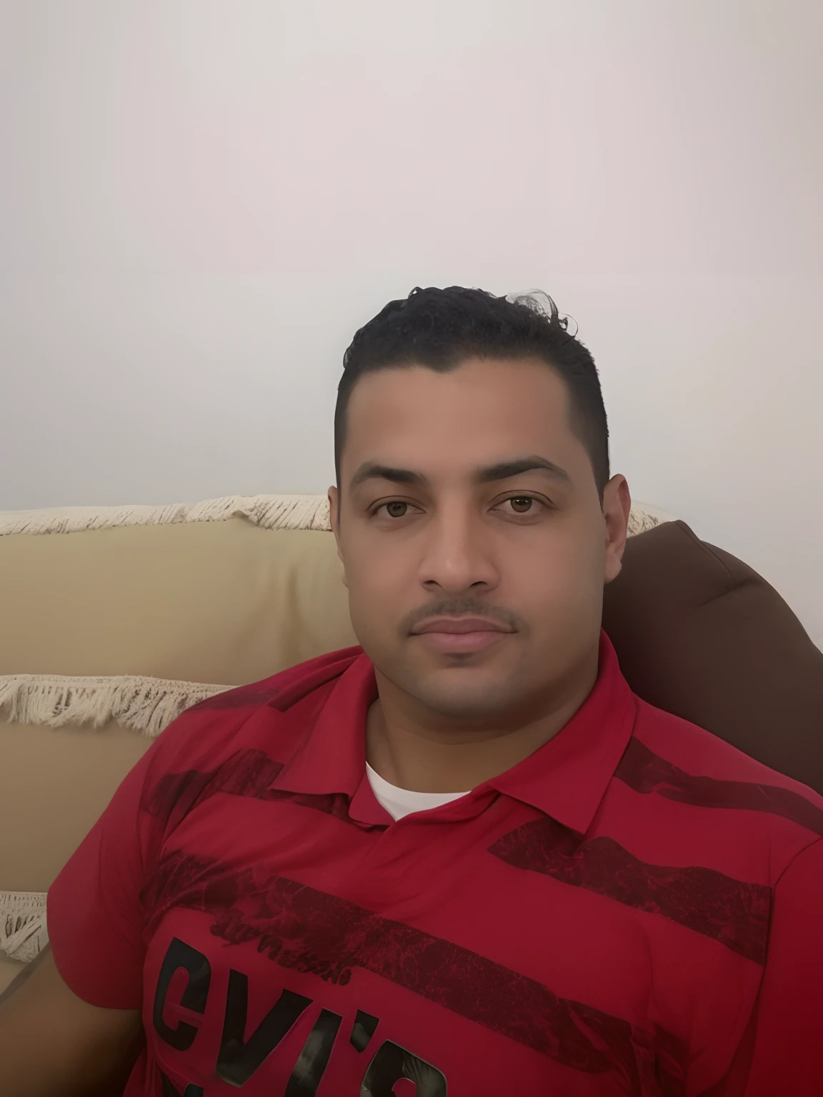 there is a man sitting on a couch with a remote in his hand, Mohamed Chahin, Emad Mostaque, andres rios, Ronaldo Luis Nazario de Lima, Alex, Mohamed Reda, Ronaldo Nazario, david rios ferreira, Ronaldo Nazario Fenomeno, Eloy Morales, Jose Miguel Romano Francisca, Ronaldo Luis Nazario da Lima