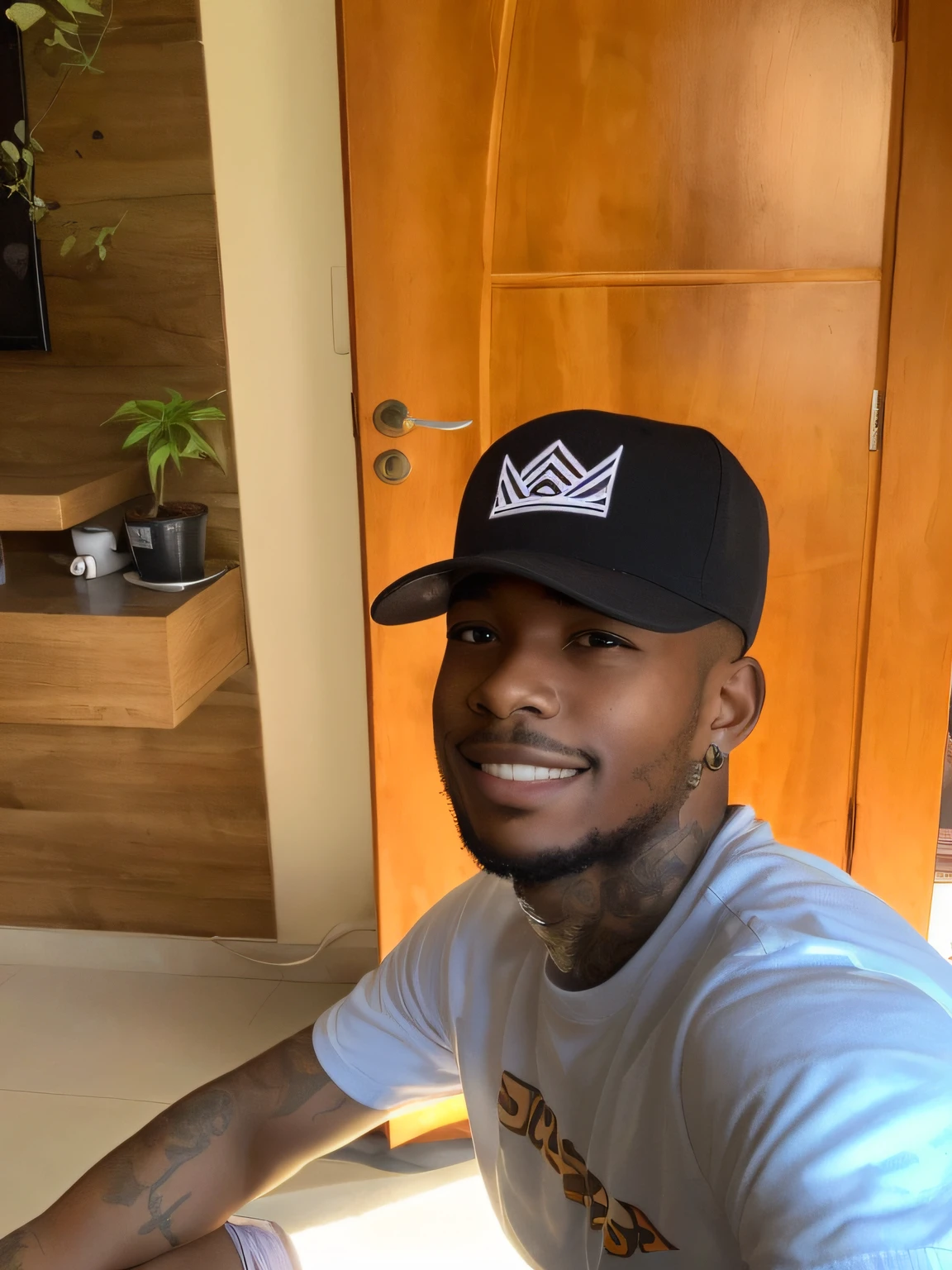Young black man sitting with tattooed arm wearing cap