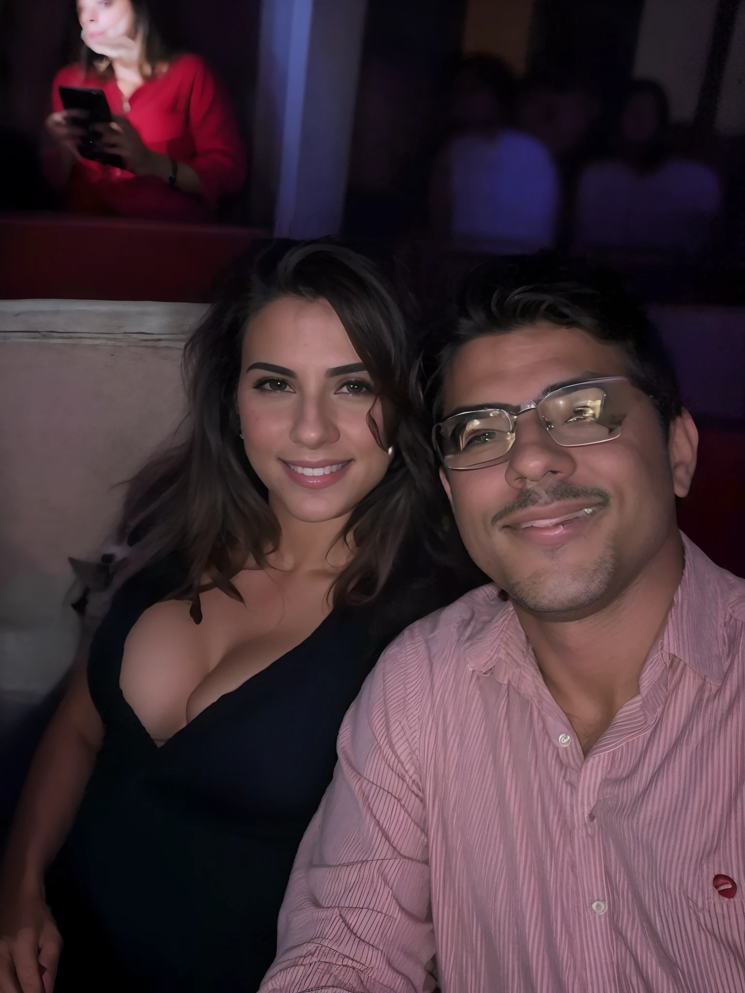 Casal pousando pra foto self, em um teatro.