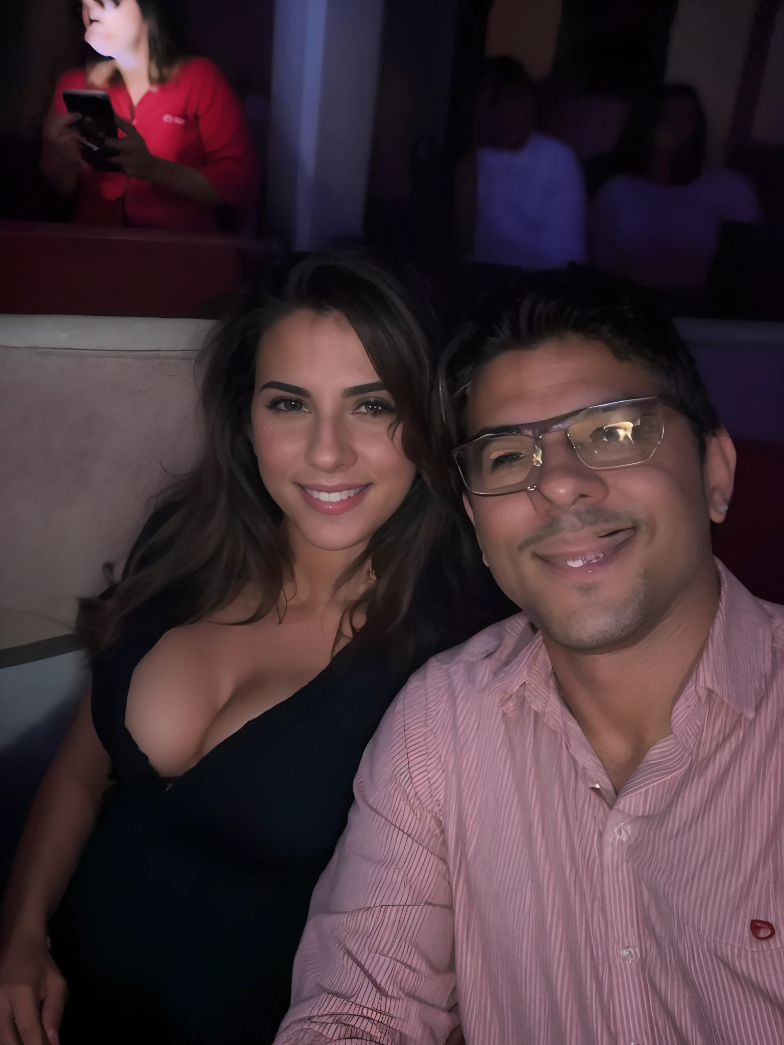 Casal pousando pra foto self, em um teatro.