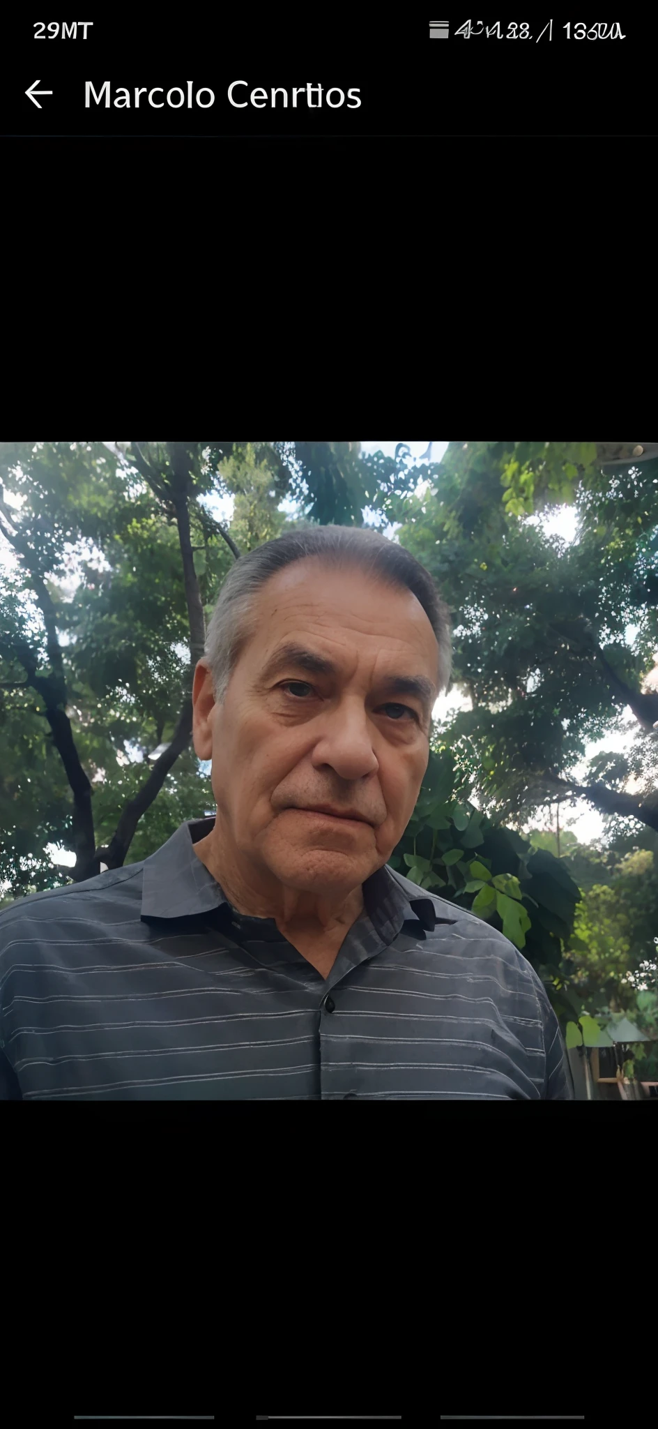 A wise old man standing in a green dress shirt written easy market on the front, illuminated by the light of a lamp, contra o pano de fundo de uma biblioteca