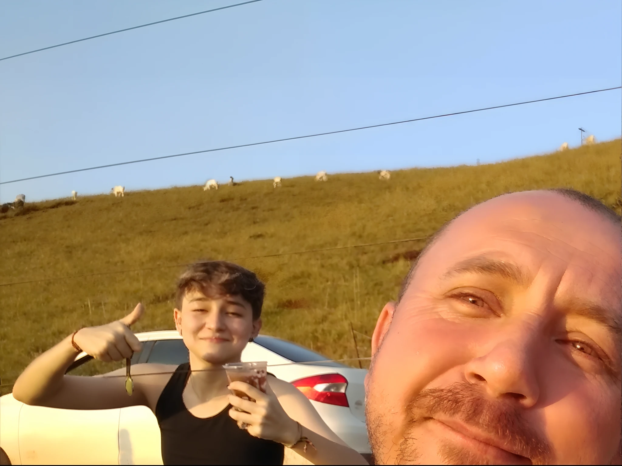 There's a Man Taking a Selfie with a Woman in the Back Seat of a Car, in the sunset, Selfie, foto Selfie, Colinas ao fundo, imagem de qualidade muito baixa, Selfie de um homem, during sunset, Selfie!!!!! de um homem, Fotografia Selfie 8k, ao nascer do sol, with sunset, Andrey Surnov, Andrei Riabovitchevy