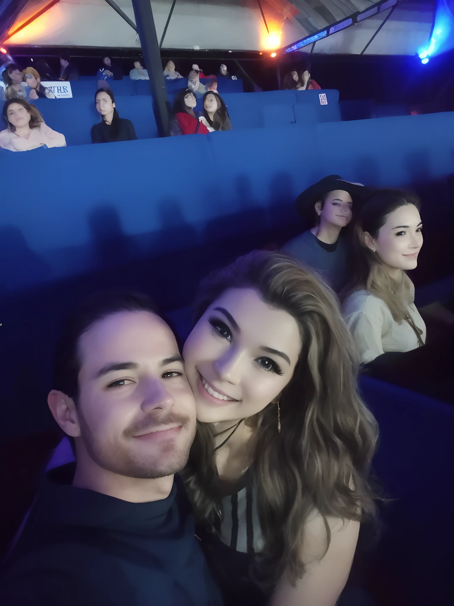 There's two people who are sitting in a theater together, audience selfie, pessoas curtindo o show, Charli Bowater e Artgeem, imagem de qualidade muito baixa, Fotografia tirada em 2 0 2 0, Tyler Edlin e Natasha Tan, Jordan Grimmer e Natasha Tan, selfie shot straight on angle, both smiling for the camera, Magali Villeneuve e Monet