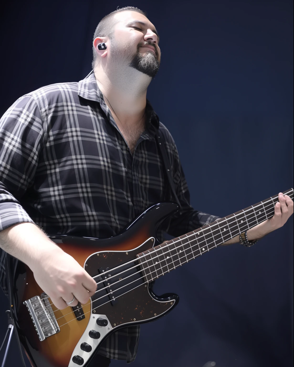 Man with beard playing Sadowsky brand electric bass on stage, camisa xadrez, baixo sunburst de 5 cordas, de olhos fechados.