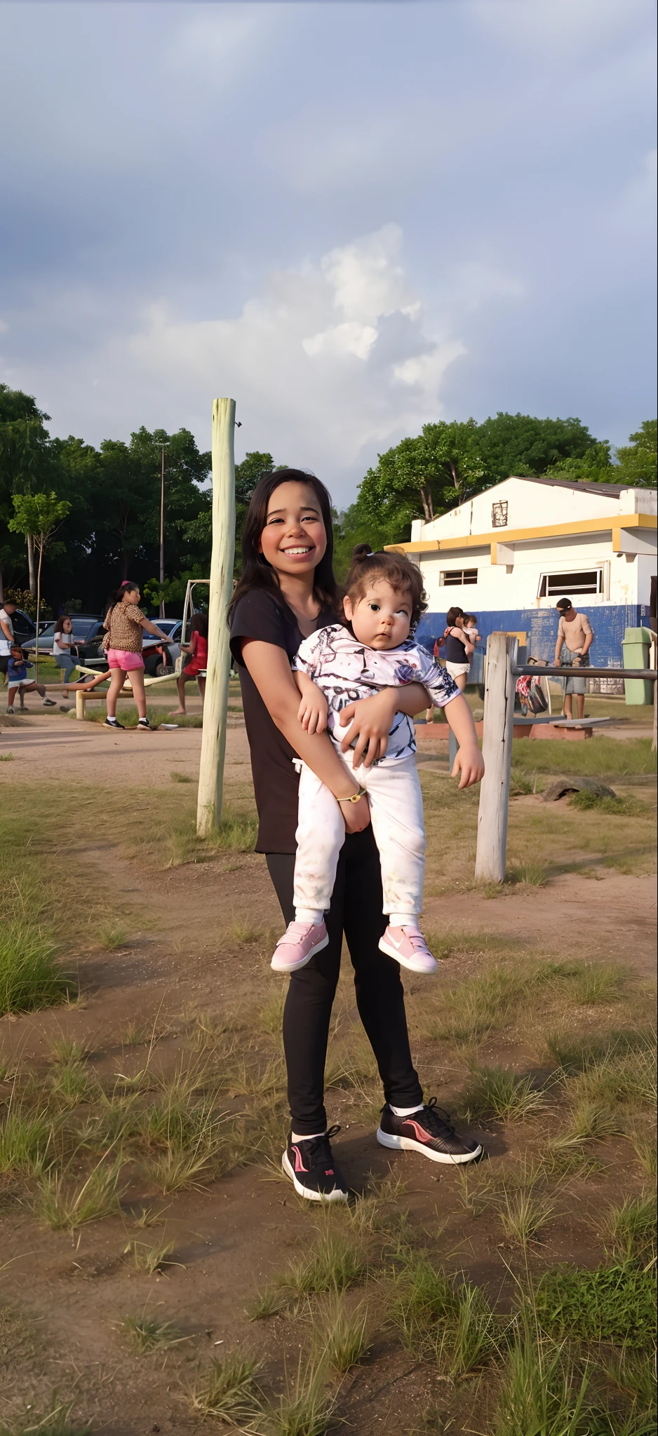 There's a girl holding a baby ifield, with a kid, com uarque ao fundo, com um parque nos fundos, no parque,