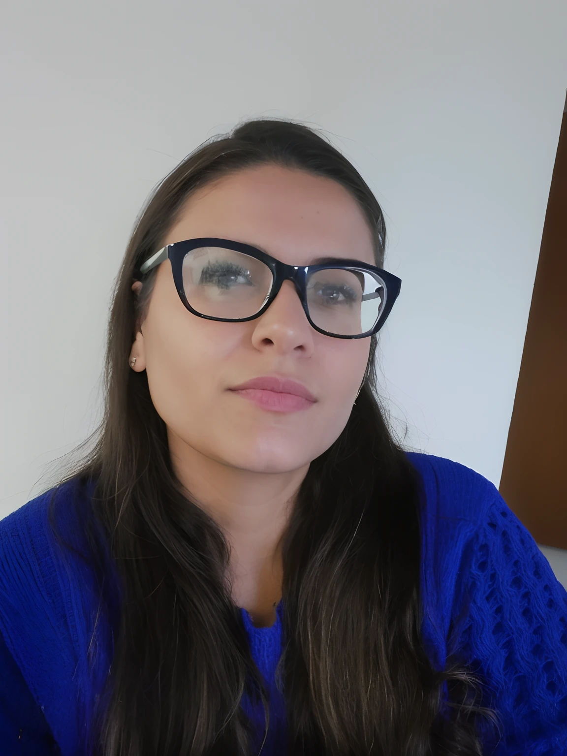 Woman with glasses and blue sweater sitting in front of a white wall, fernanda suarez, Directed by: Nandor Soldier, Estefania Villegas Burgos, photo of džesika devic, imagem de perfil, Anos Imane, Magalie Villeneuve, Valentina Embaralhamento, Adriana DXIM, Foto realista
