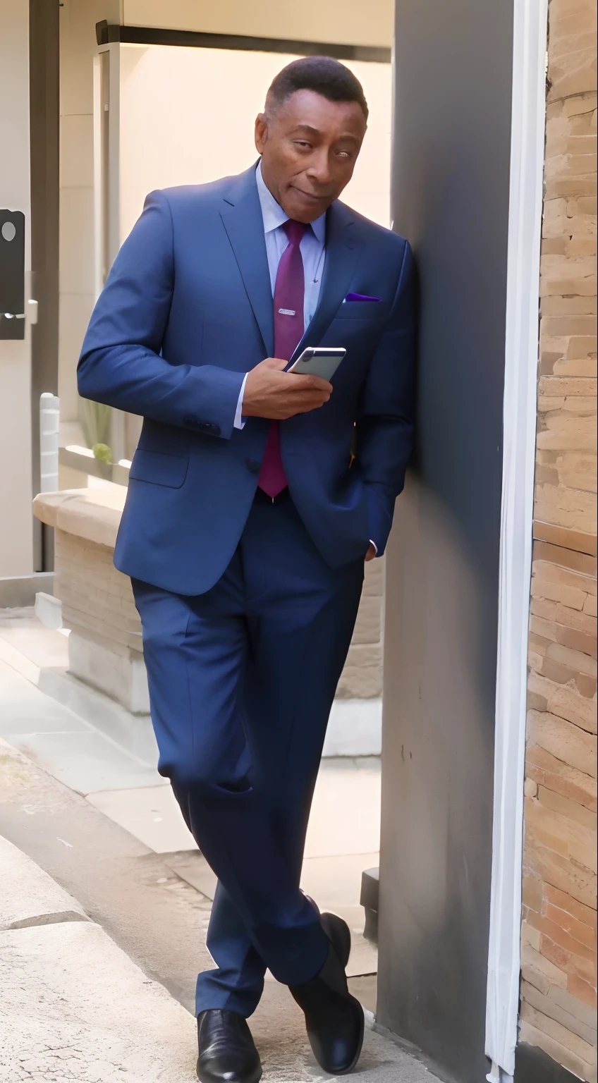 Homem com 30 anos, pele morena, cabelo curtinho preto vestindo terno azul e gravata roxa, Using a cell phone in his hands leaning against a wall.