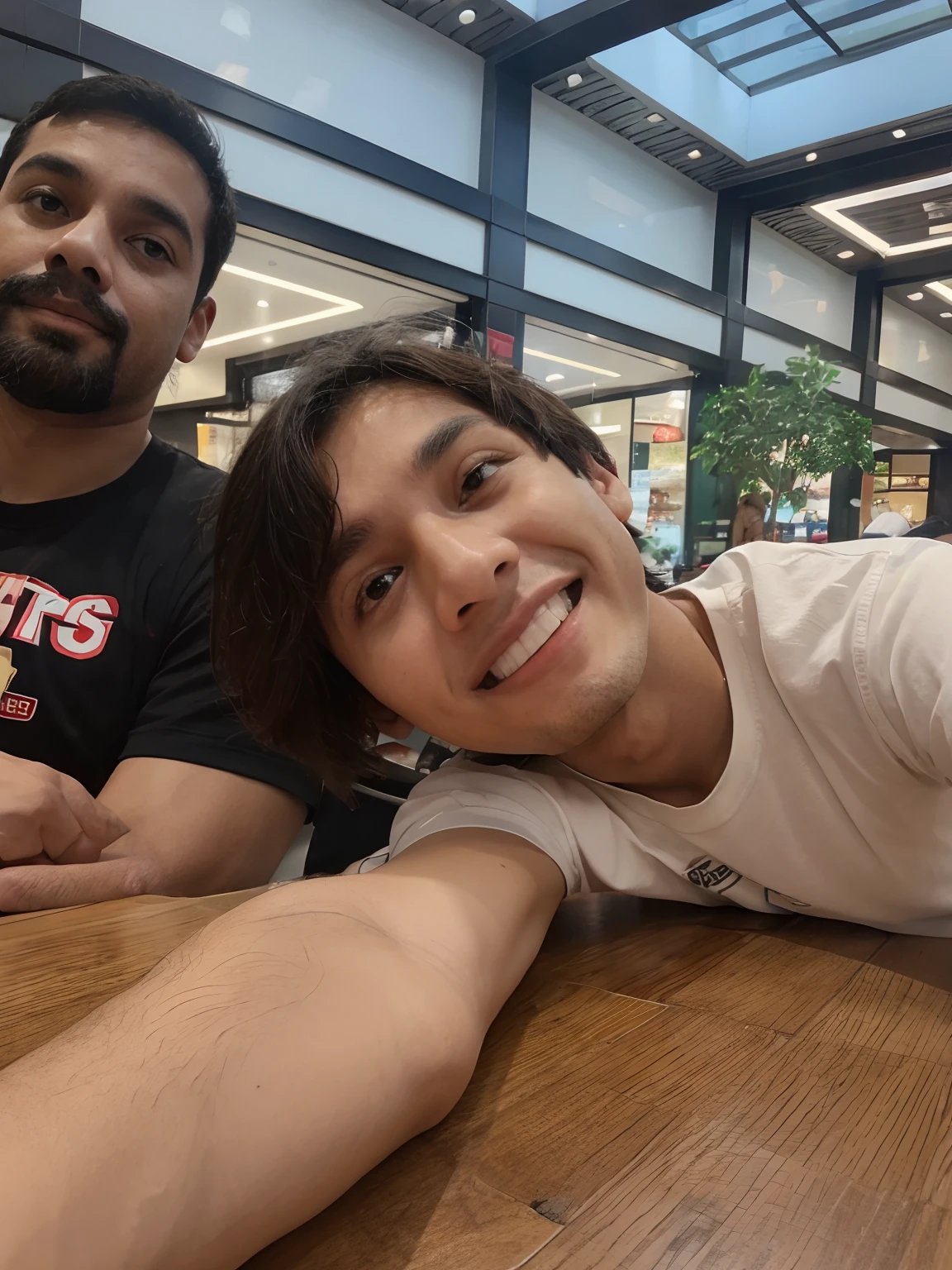 Pai e filho sentado na cadeira em uma mesa de shopping