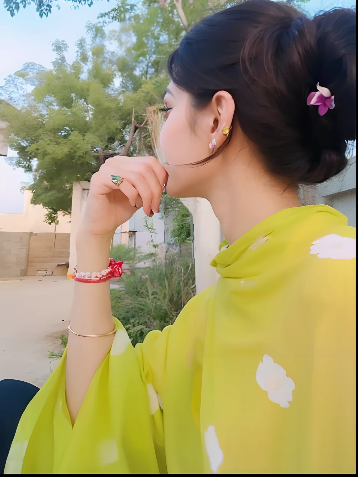 there is a woman sitting outside with a cell phone in her hand, with lovely look, candid picture, very beautiful enga style, very very low quality picture, with beautiful colors, with yellow cloths, candid photograph, wearing wheat yellow gauze, very beautiful photo, wearing jewellery, traditional beauty, profile pose, wearing a silk kurta, with small studded earings