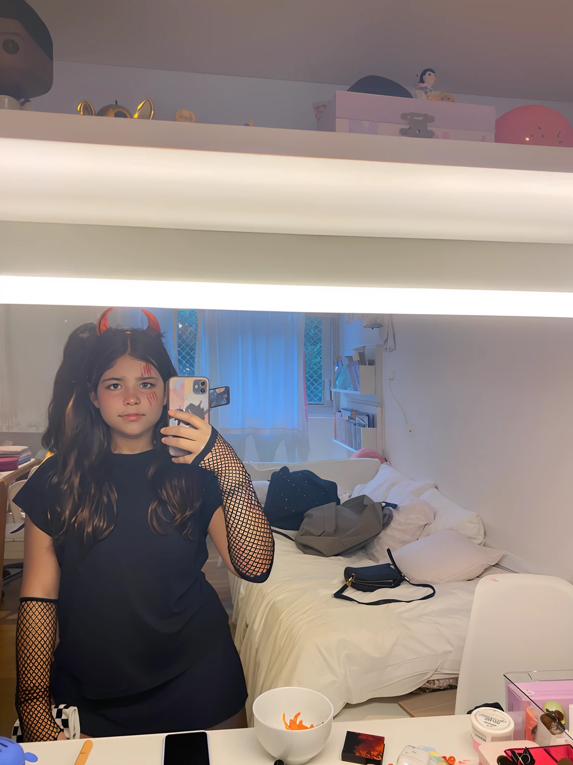 Uma menina de cabelo castanho escuro ondulado, olhos castanhos e de roupa de Halloween