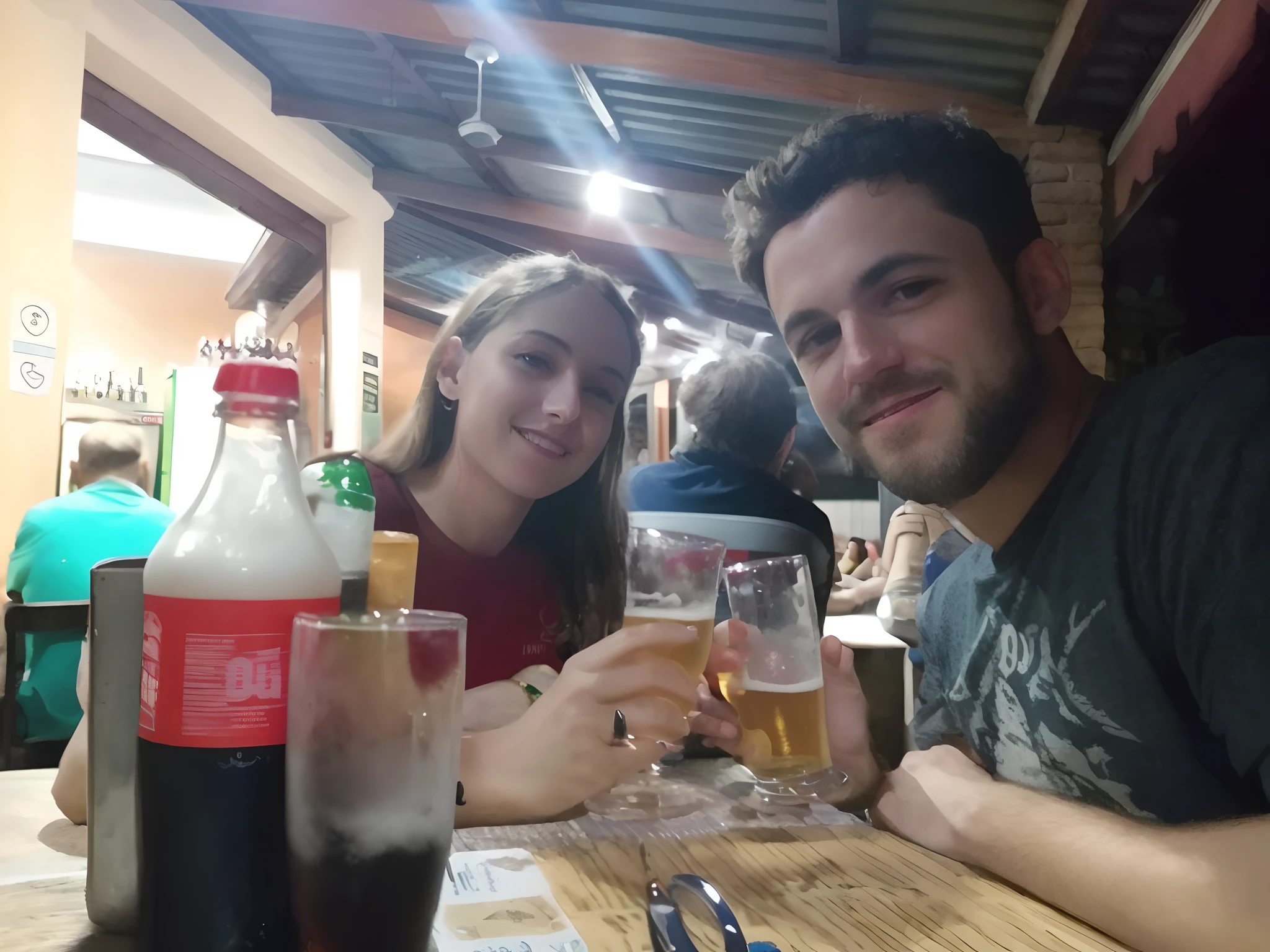 there are two people sitting at a table with drinks and drinks, obrigada, pessoas bebendo cerveja, no pub, Noite!, com uma bebida, segurando uma cerveja!!, beber cerveja, beber uma cerveja, Casal feliz, drinking a beer at train station, Directed by: Nandor Soldier, vacation photo, cerveja, Buy beers at the British bar, segurando cerveja