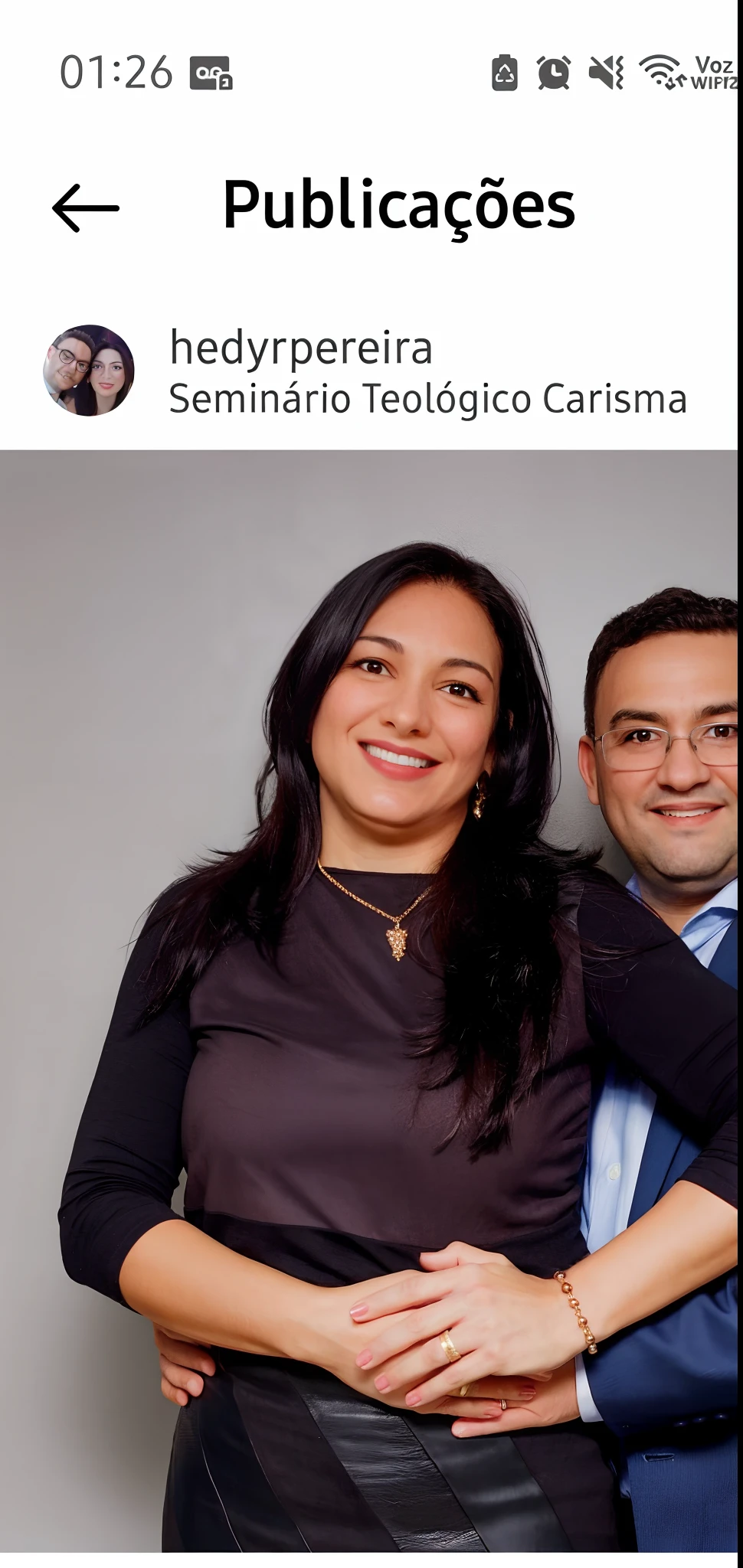 A woman with long hair and a man with glasses and suit