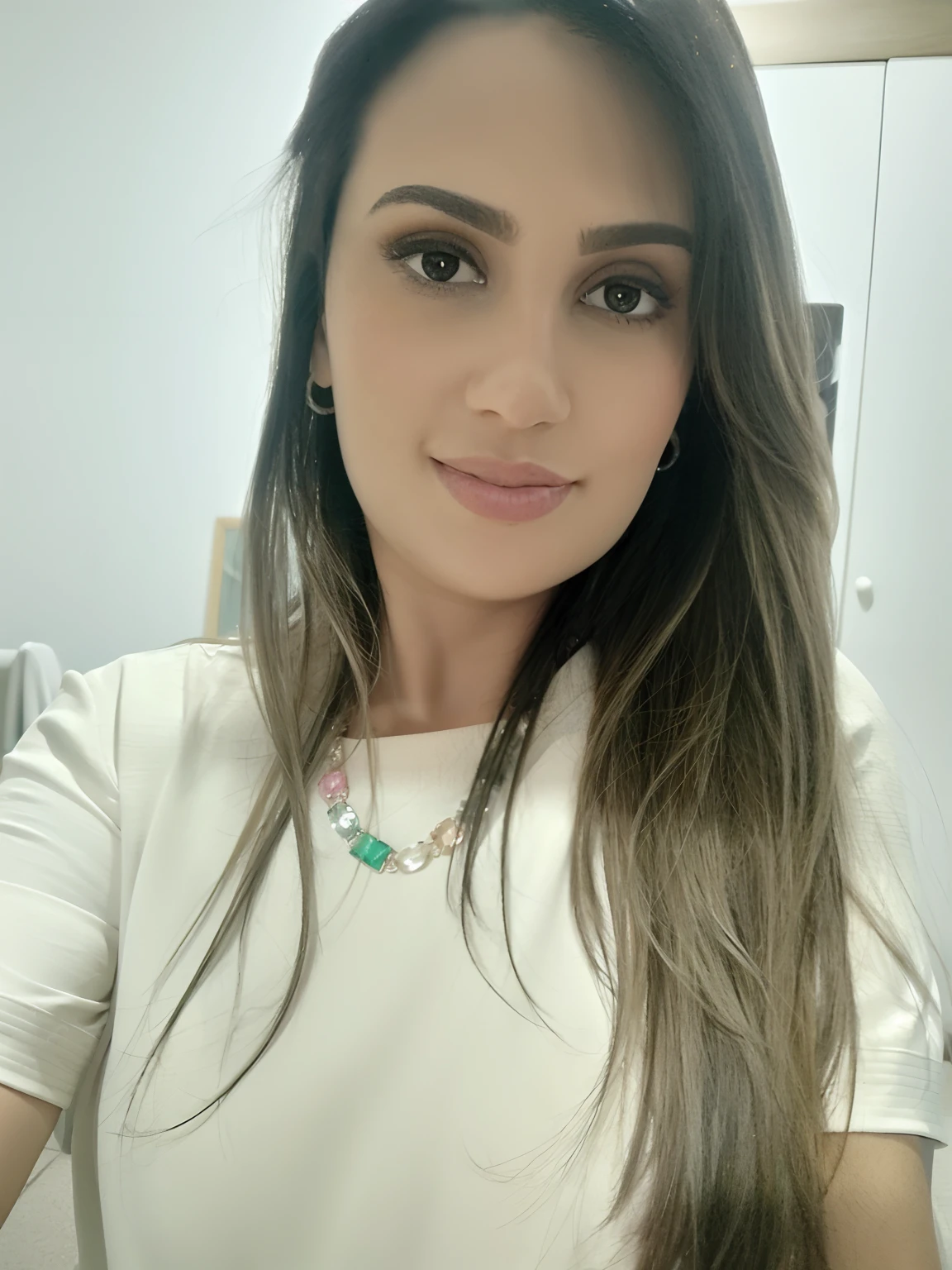 Mulher cabelos longos lisos, com uma blusa cor creme e um colar